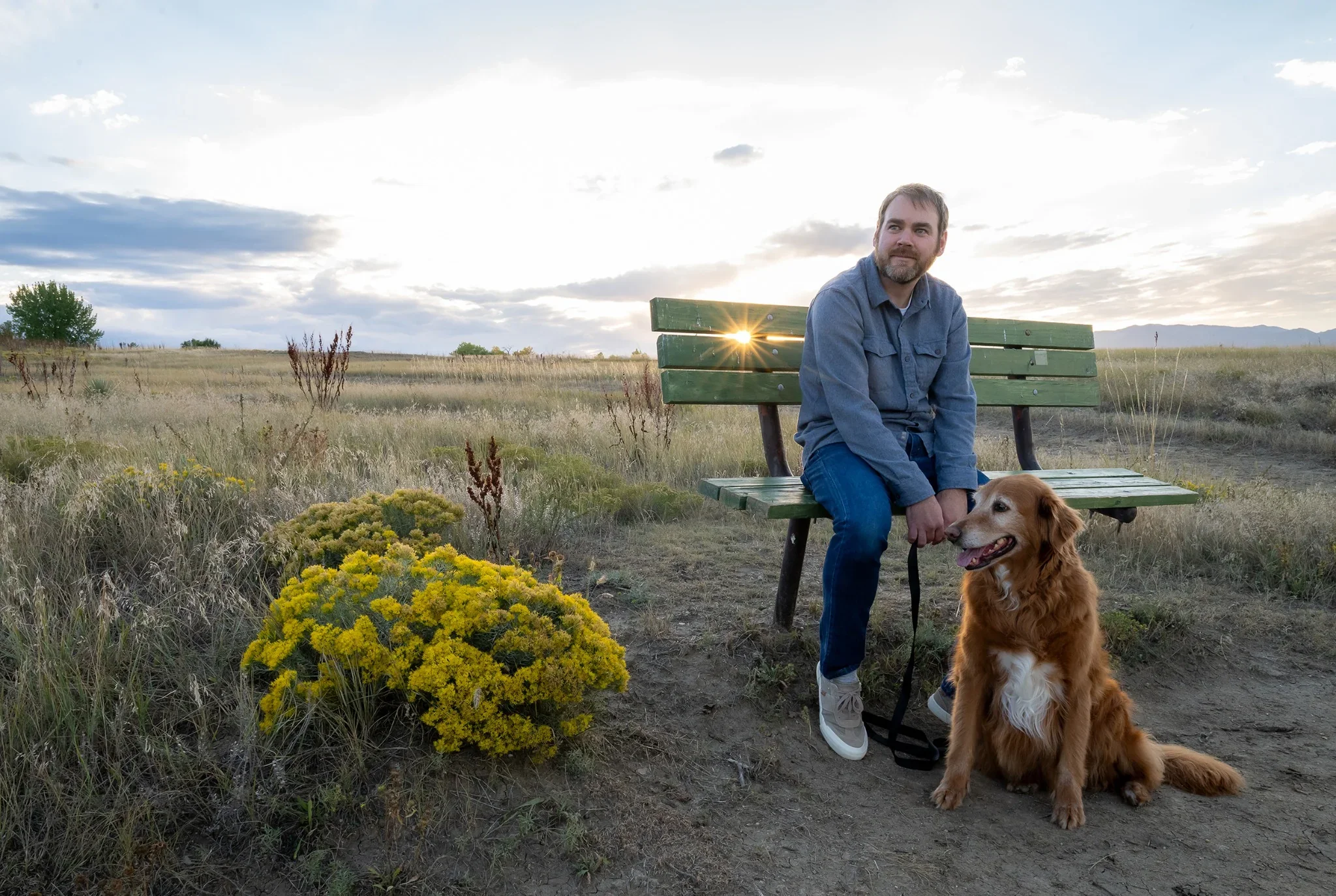 A man and his trusty golden retriever sit on a park bench at Standley Lake in Westminster, Colorado Relaxed, natural family photography captured by Ryan Kost.
