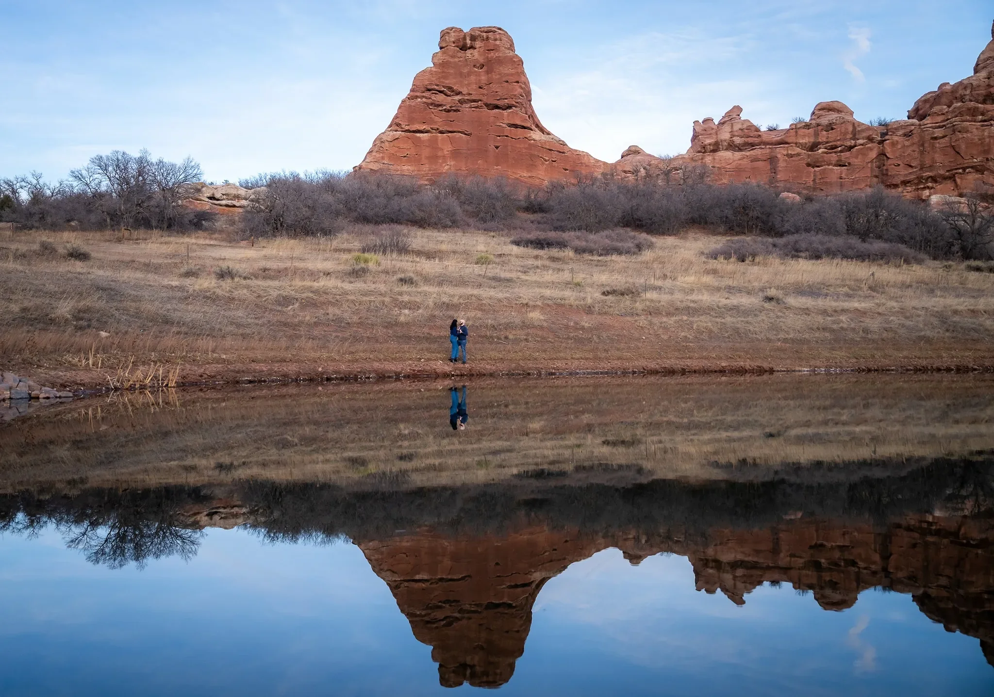 Dramatic reflection engagement portrait with red rocks and pond at South Valley Park in Littleton, Colorado by Ryan Kost Photography