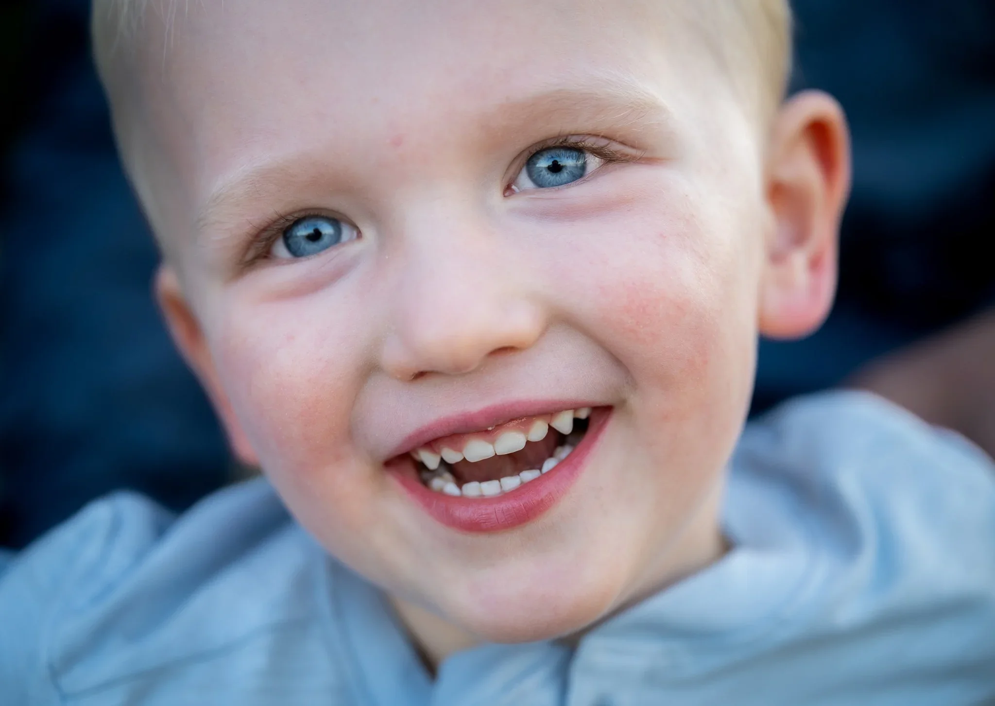 Close up portrait of young boy smiling wide at Standley Lake in Westminster, Colorado Relaxed, natural family photography captured by Ryan Kost.