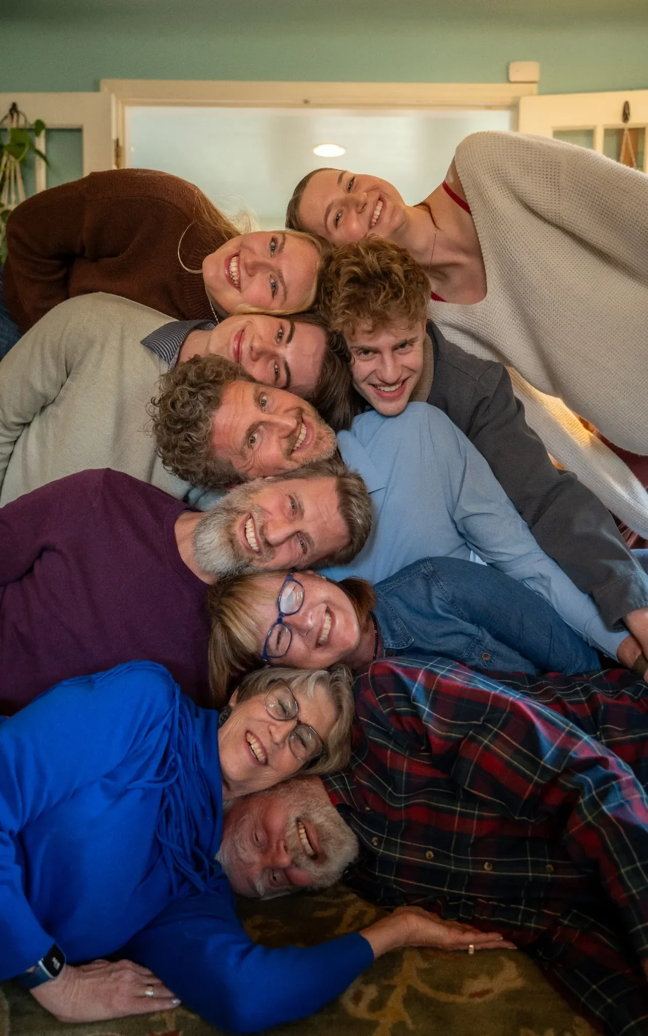 Fun head stacking family photo at home in Denver, Colorado during the holidays captured by Ryan Kost Photography