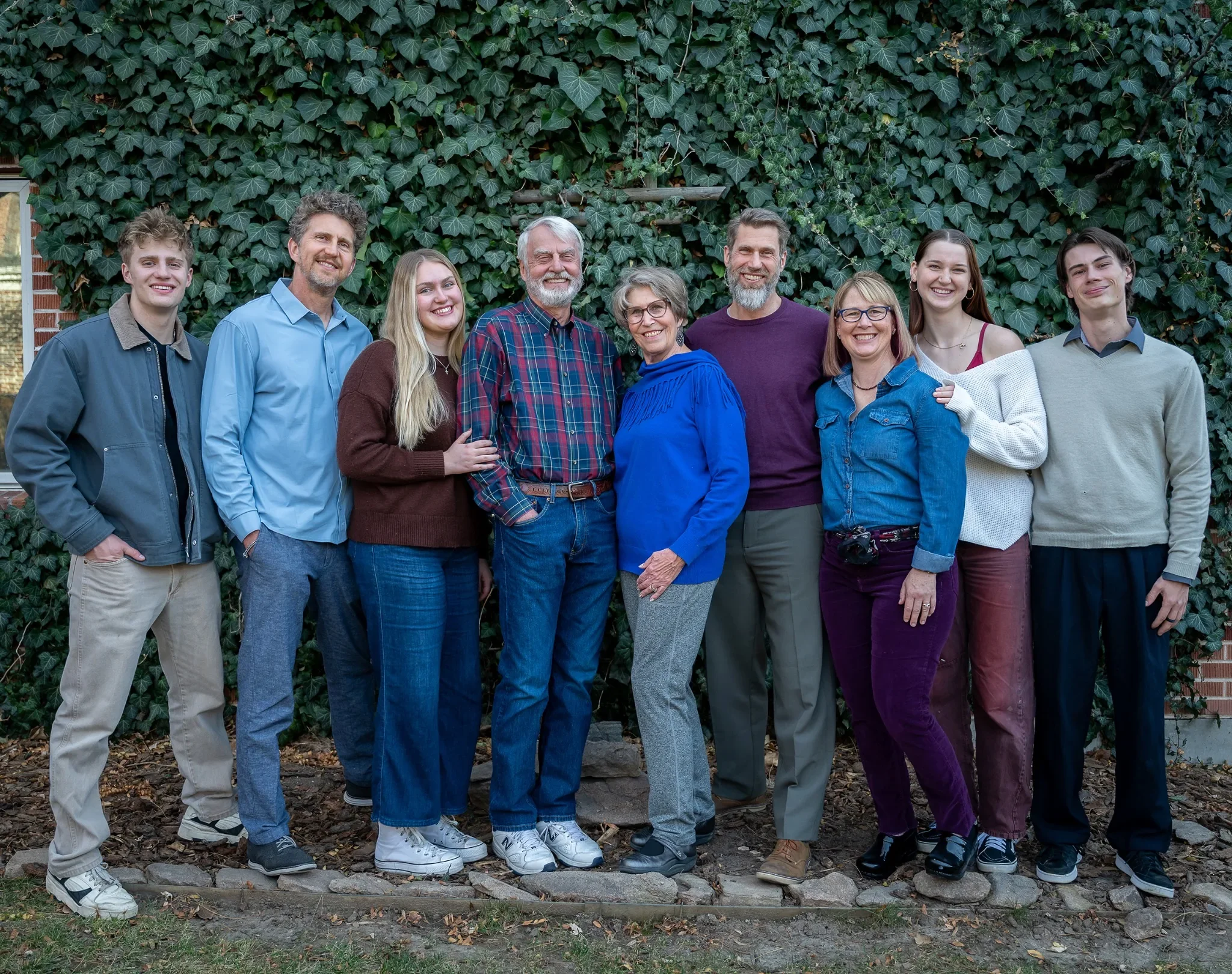 Large, natural family portrait in backyard during an in home documentary family photo session in Denver, Colorado captured by Ryan Kost.