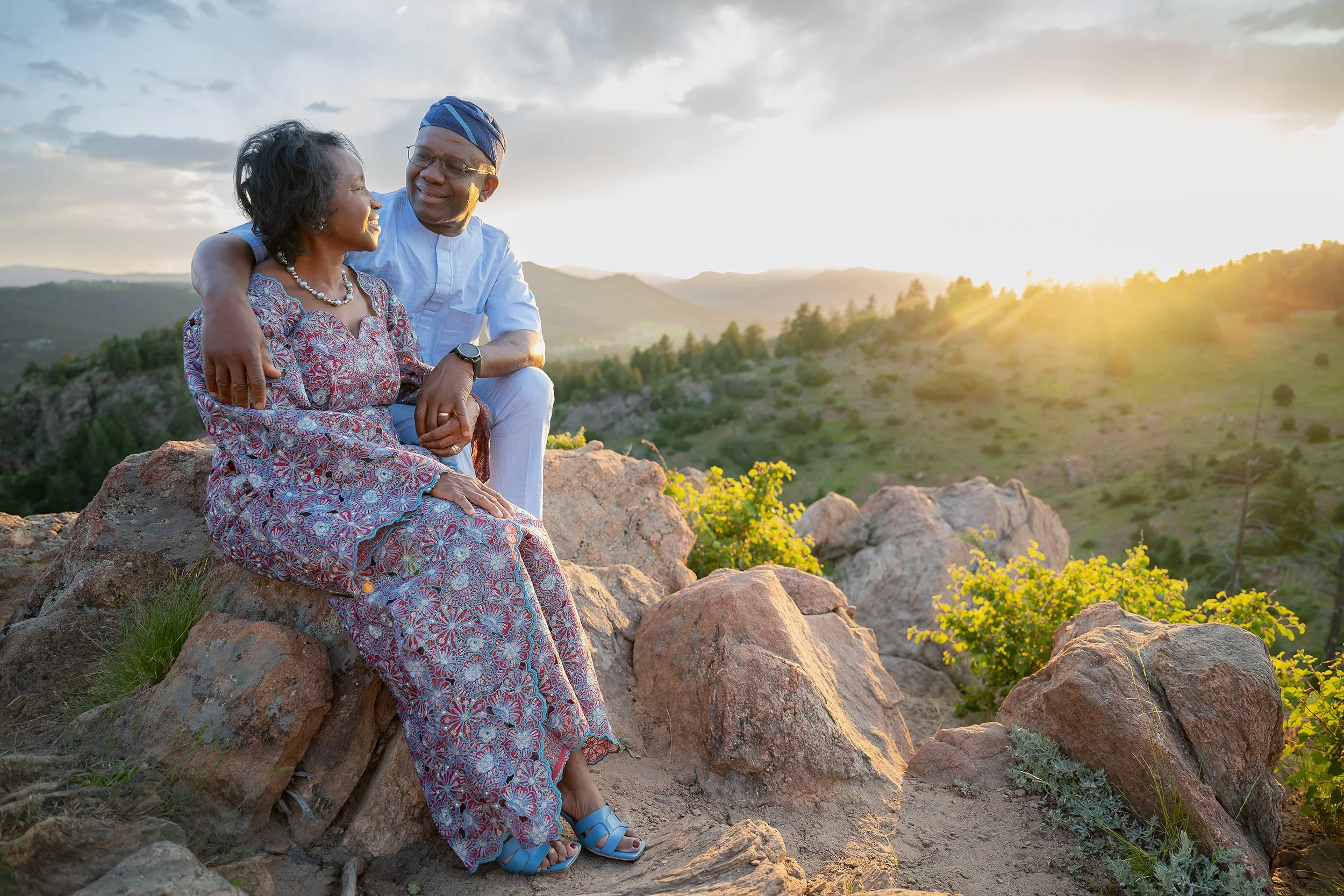 Grandparents giving loving looks and taking a quiet moment of gratitude and love under the golden light at Mount Falcon West Trailhead. Colorado family photography captured by Ryan Kost