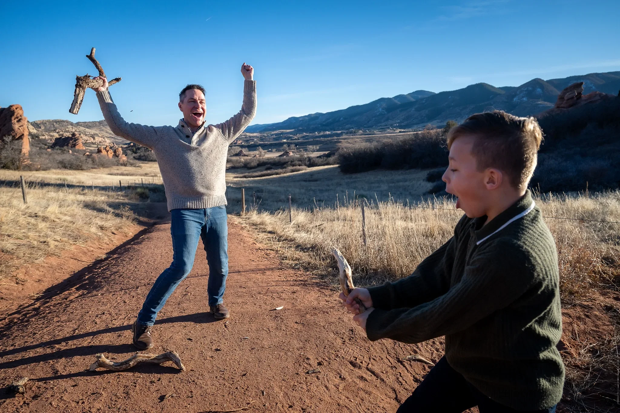 Stick sword fighting. Outdoor family photography session at South Valley Park Littleton Colorado.