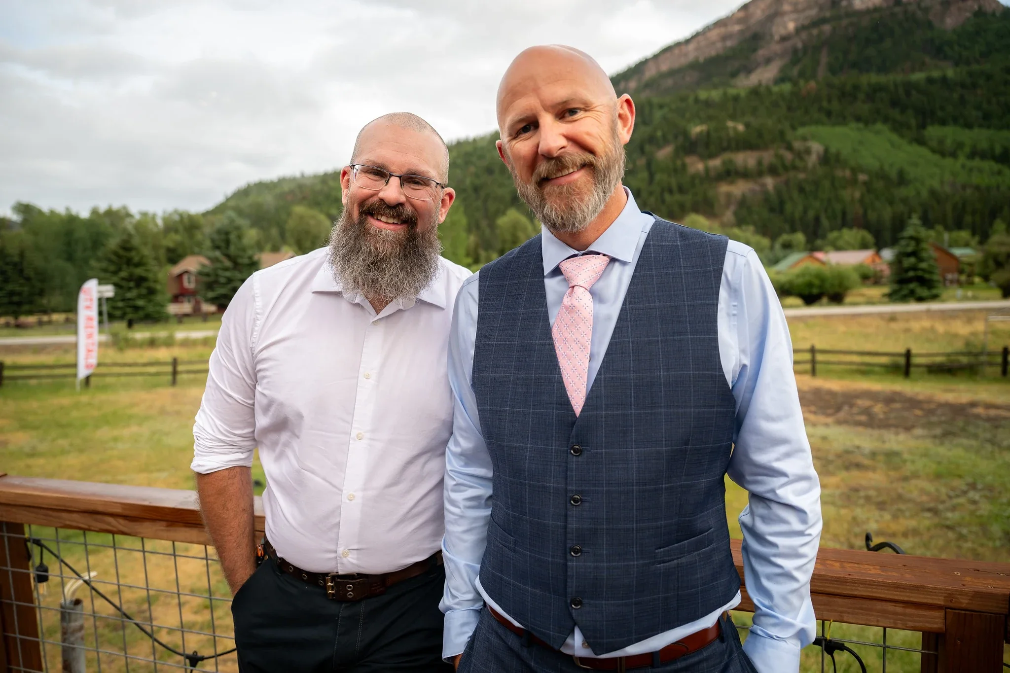 Groom and Best Friend share smiles outside of Red Bear Haus at wedding reception in Horca, Colorado.