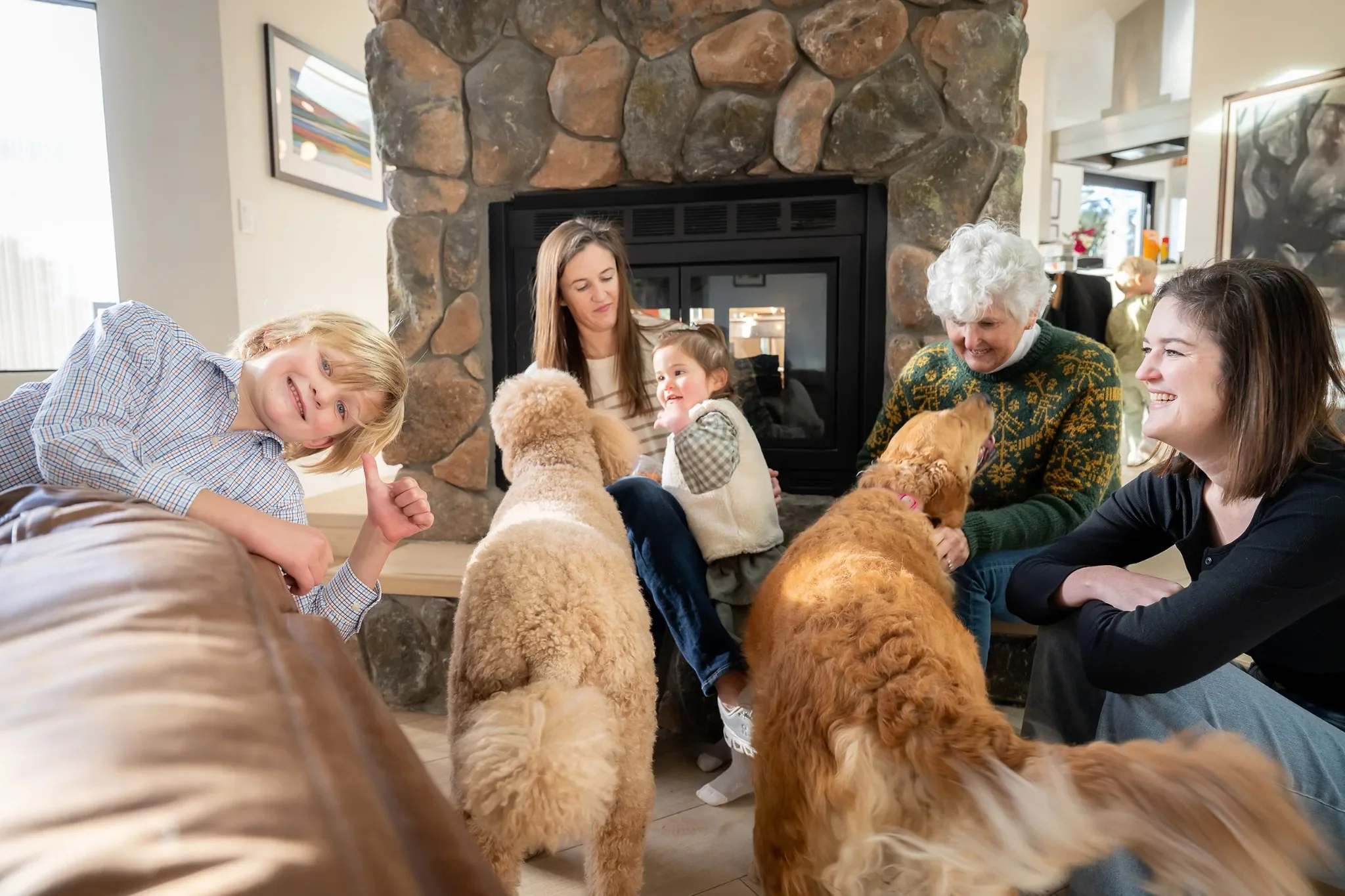 Documentary-style family photo playing with dogs inside a mountain home in Indian Hills during a Colorado family session