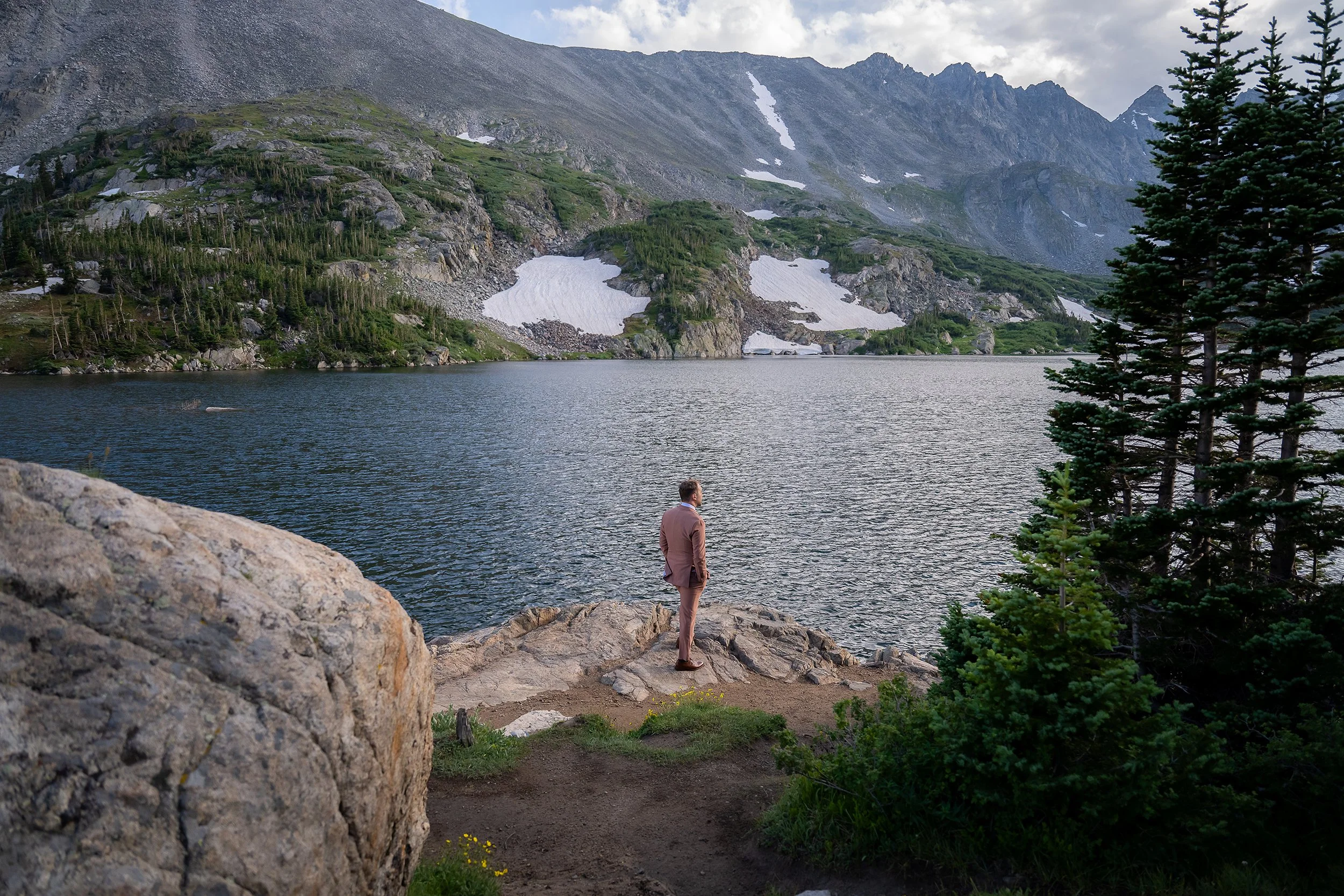 Groom takes in the view at Lake Isabelle during a peaceful moment before his Colorado mountain elopement ceremony in Indian Peaks Wilderness.