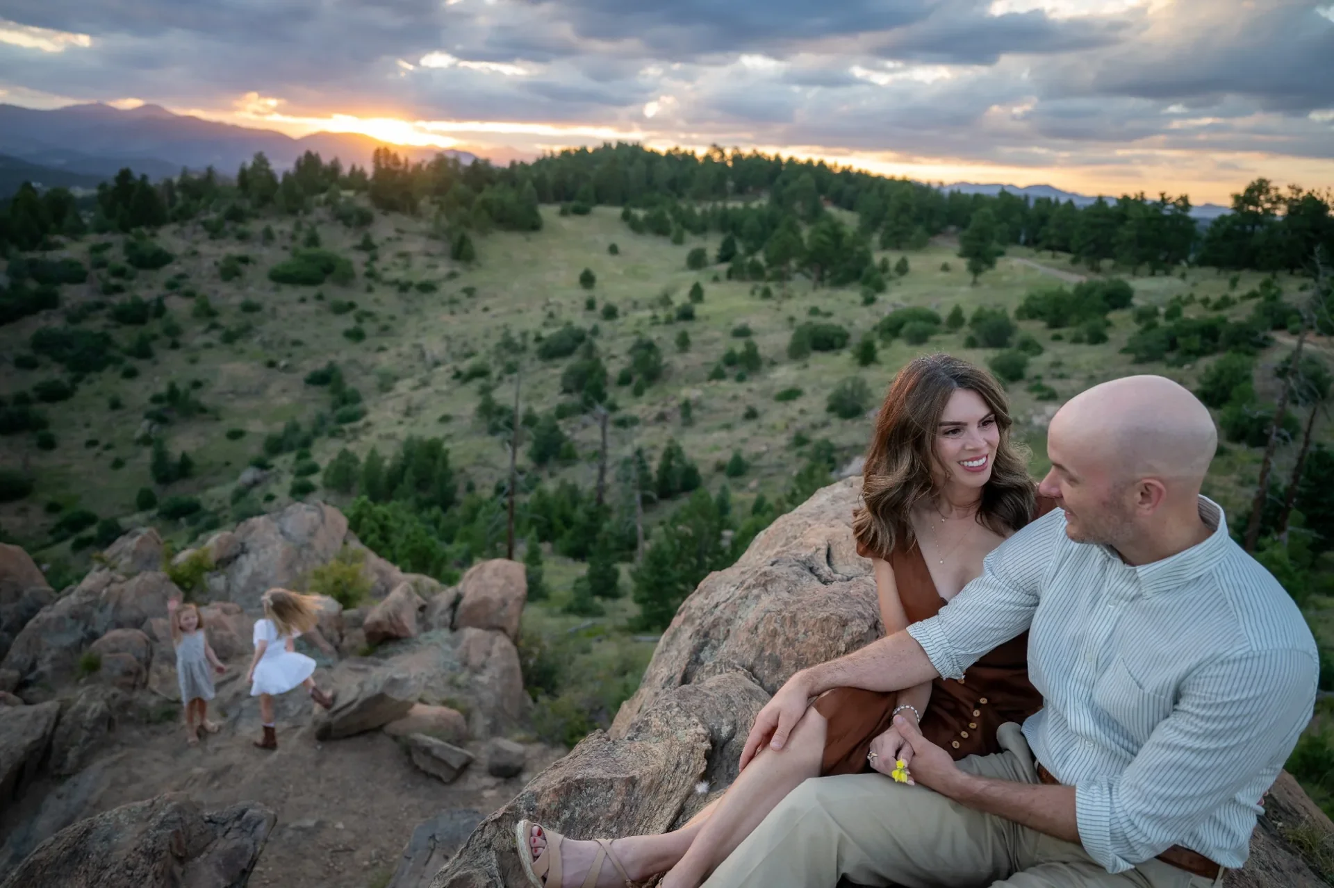 Parents enjoying a quiet sunset moment during a family photography session at Mount Falcon West in Indian Hills, Colorado.