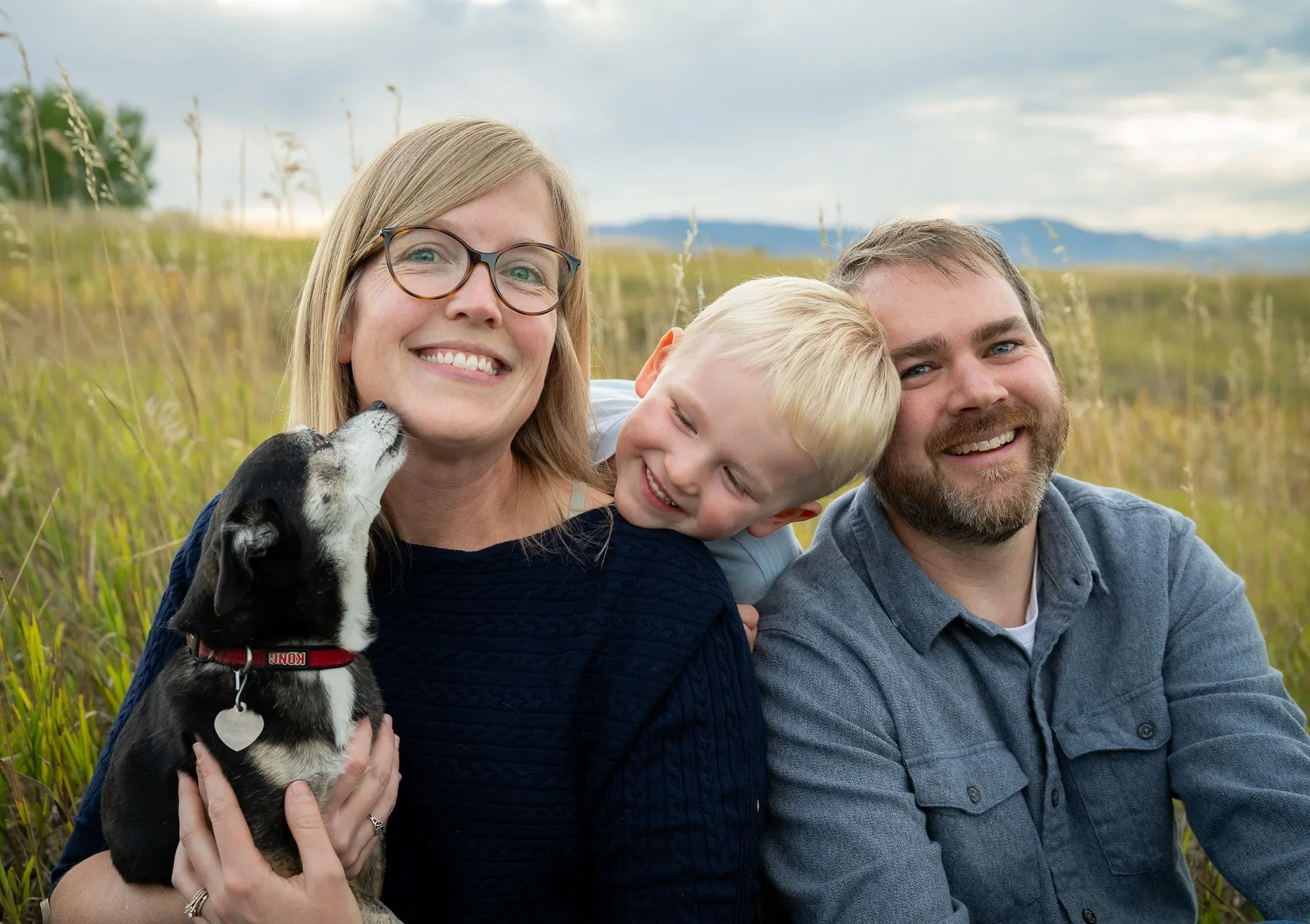 Cute family portrait with dog giving kisses at Standley Lake in Westminster, Colorado. Relaxed, natural family photography captured by Ryan Kost.