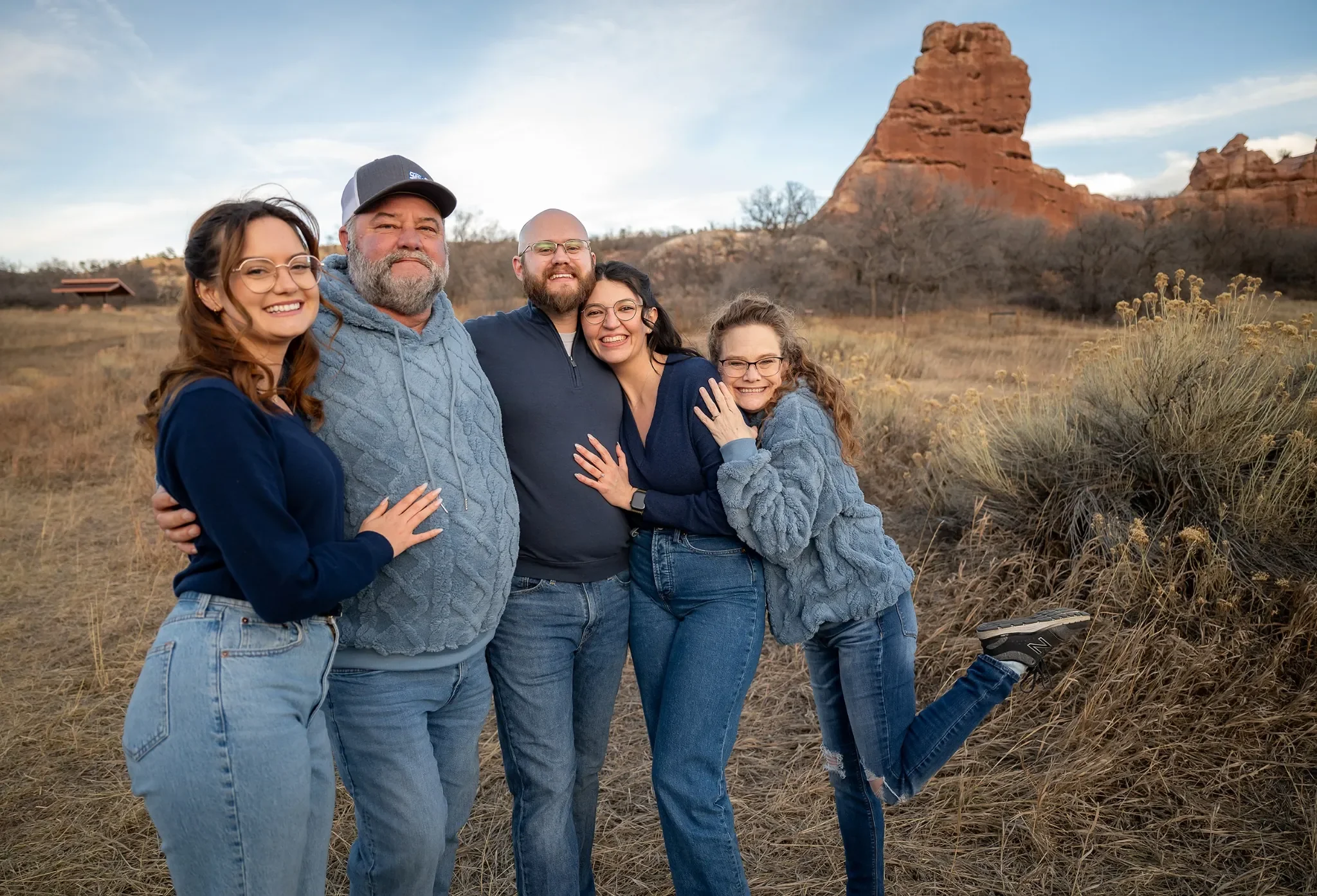 Family celebrating a surprise engagement at South Valley Park in Littleton, Colorado with red rock scenery, photographed by Ryan Kost