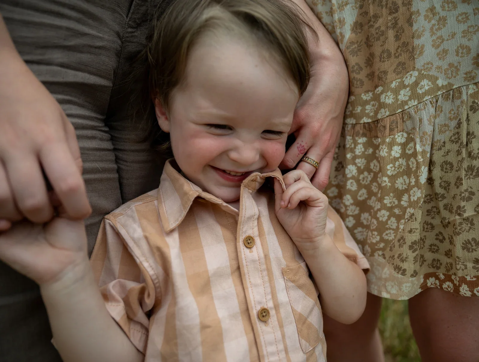 Candid portrait of a young boy smiling during a family photography session at Red Rock Canyon Open Space in Colorado by Denver family photographer Ryan Kost