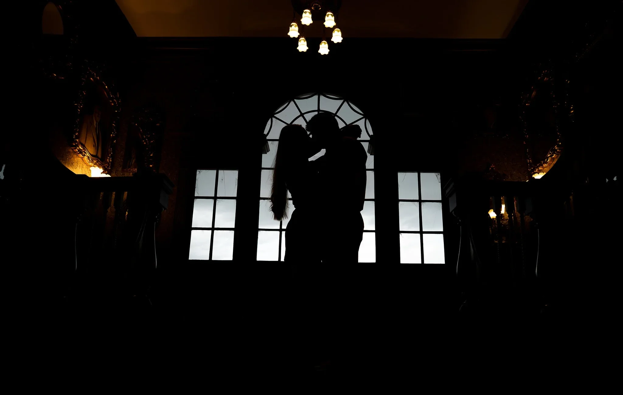 Dramatic silhouette of couple kissing during an engagement session inside the Stanley Hotel in Estes Park captured by Ryan Kost
