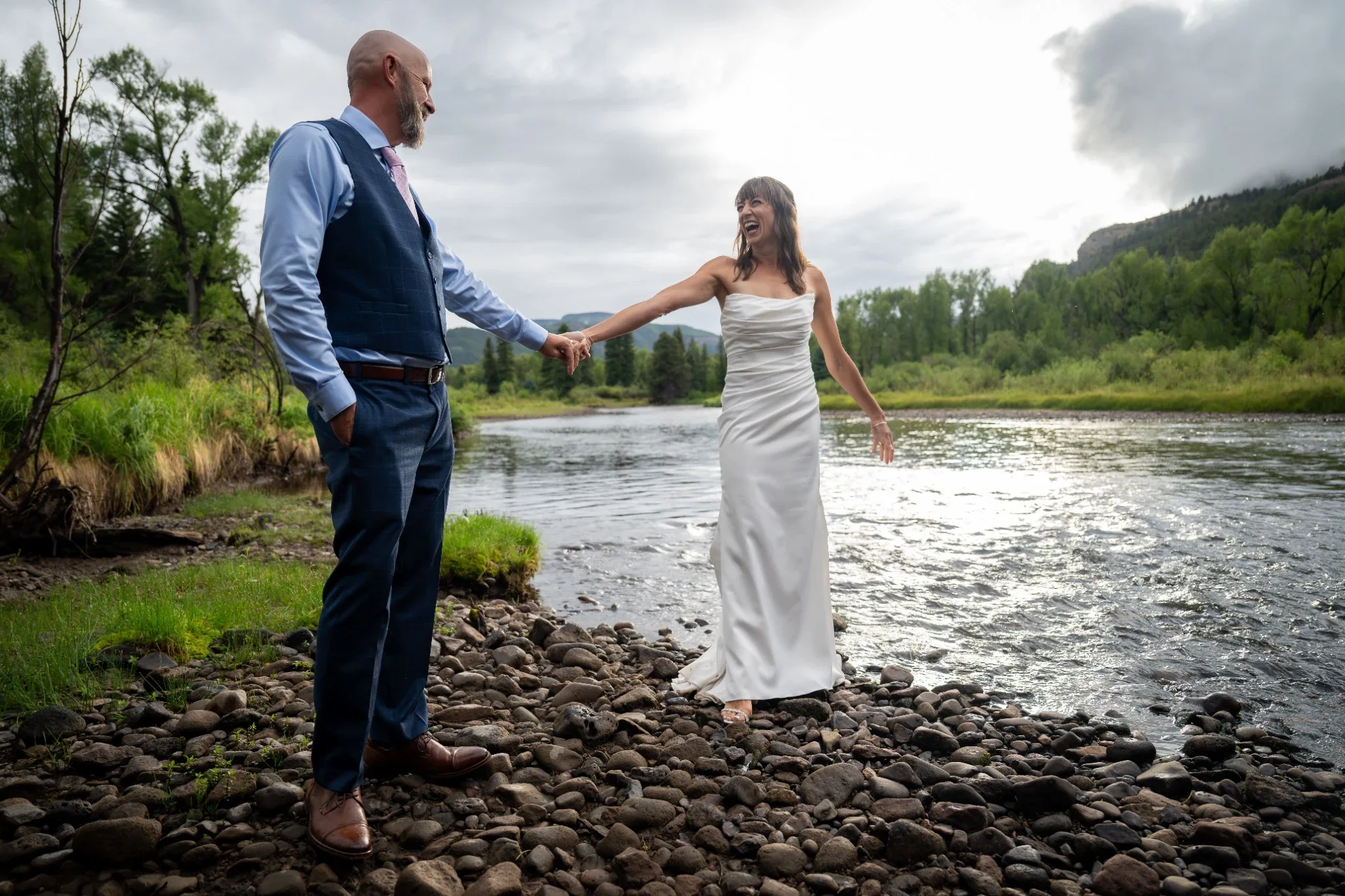 Bride and Groom portrait beside Conejos River in Horca, Colorado. Wedding photography by Ryan Kost.