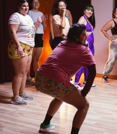 Group of women watching a woman dance at a party or celebration.