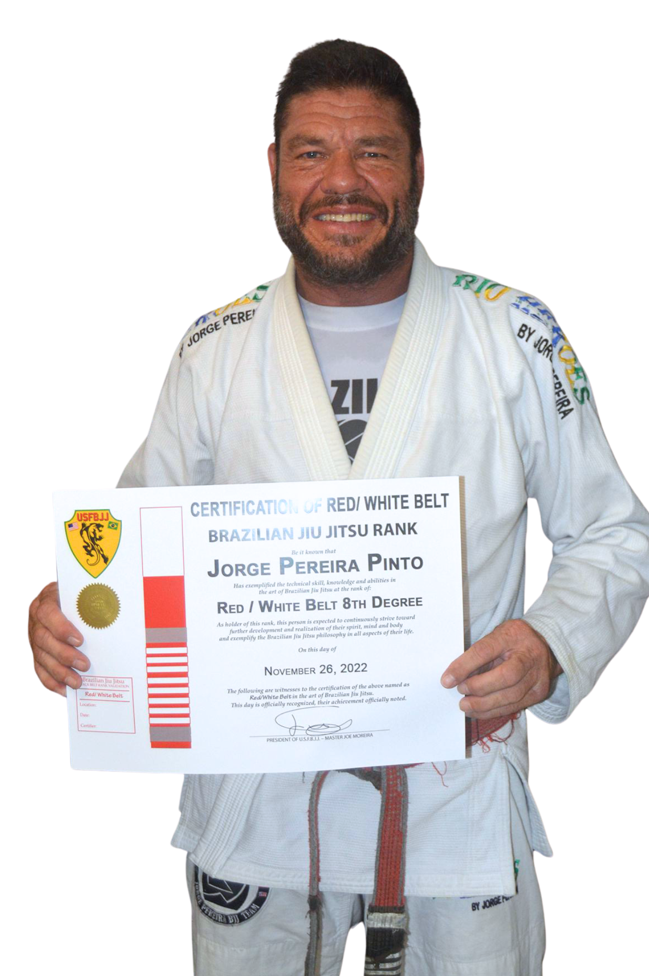 Man in a white Brazilian Jiu Jitsu gi holding a certificate for achieving a Red/White Belt, standing against a plain background.