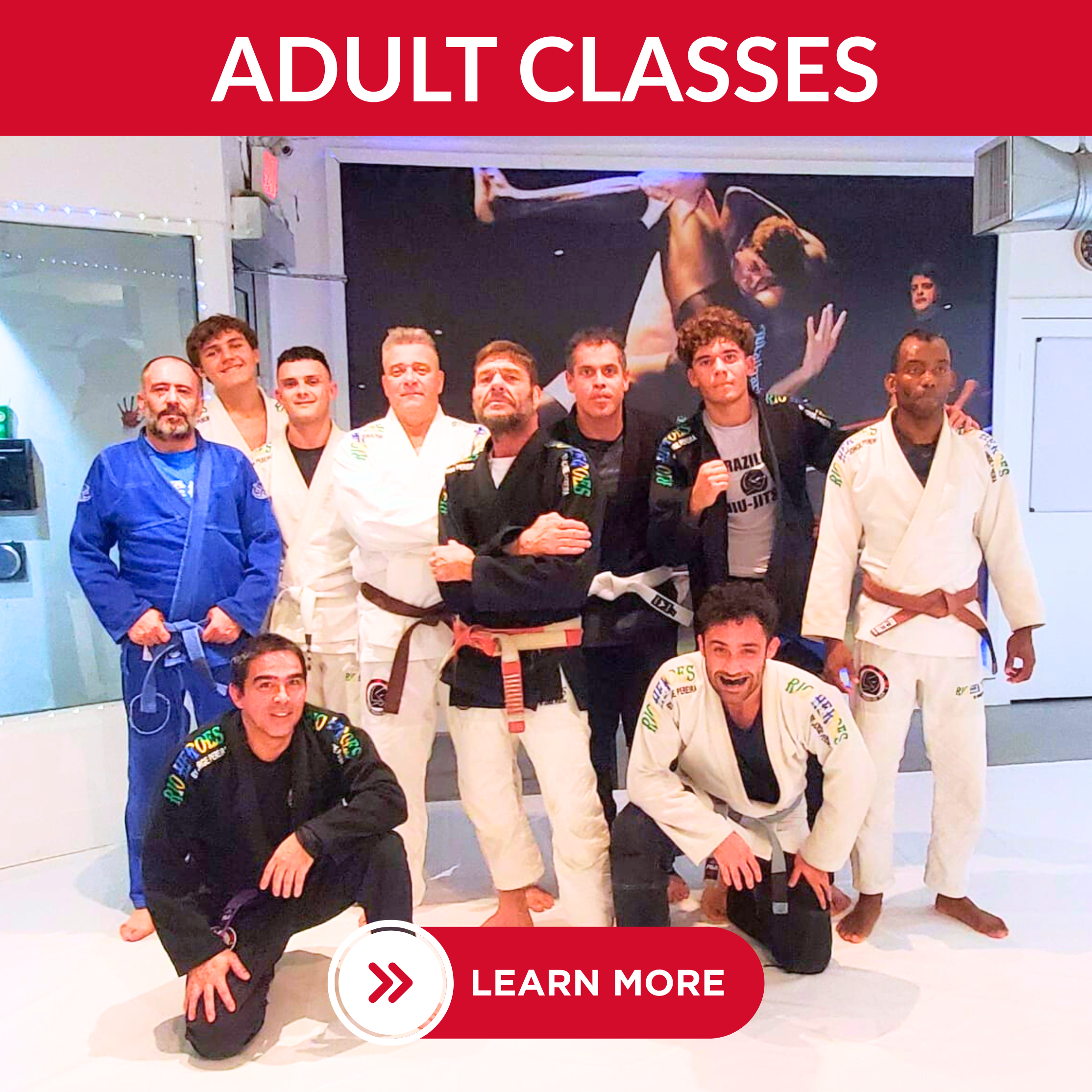 Group of Brazilian Jiu-Jitsu practitioners posing in a dojo, some wearing gis and belts, with a red banner at the top reading 'Adult Classes' and a red button below labeled 'Learn More'