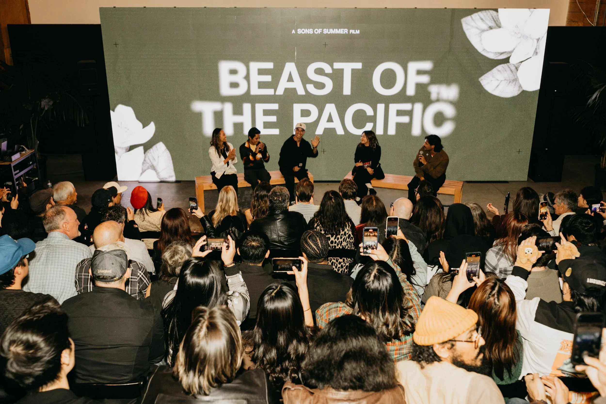 Panel discussion at an event for the film 'Beast of the Pacific,' with five people seated on stage and a large screen behind them displaying the film's title.