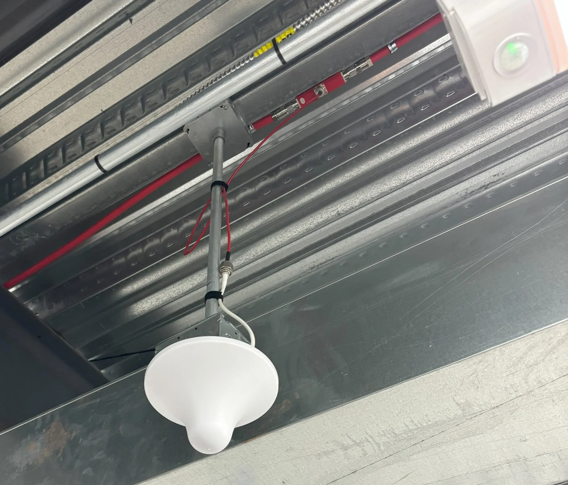 Ceiling with industrial ductwork and a suspended LED light fixture.