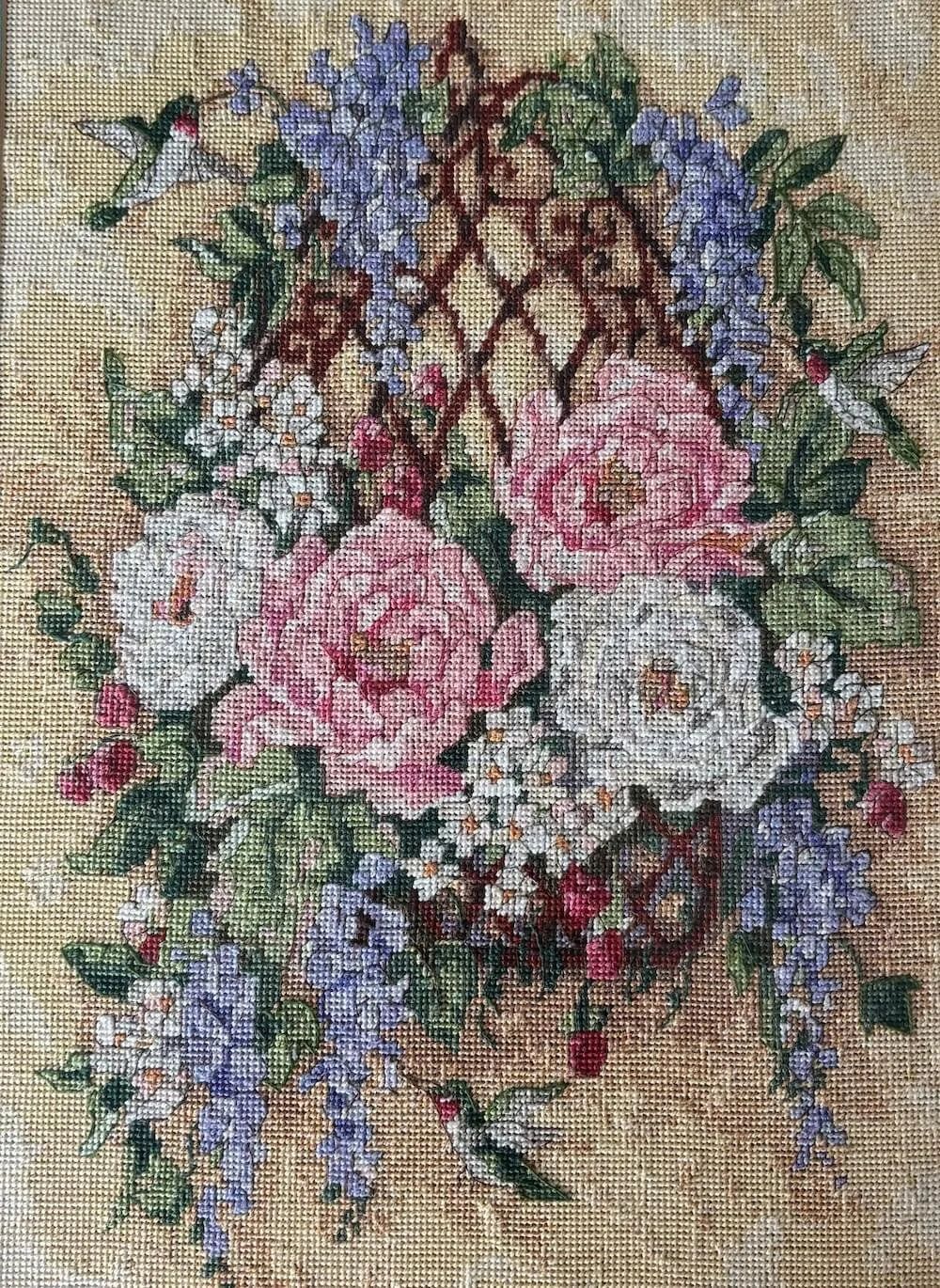 Bordado de un florero de cerámica azul con flores rosadas y blancas