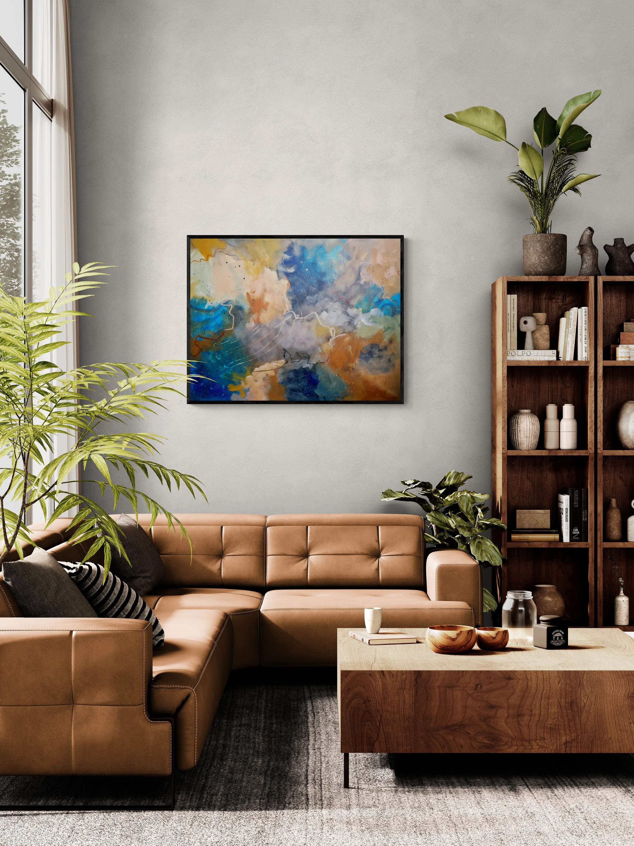 Modern living room with tan leather sectional sofa, black and white throw pillows, abstract painting, wooden coffee table with decorative bowls and candle, bookshelf with art pieces and books, potted plants, and large window with white curtains.