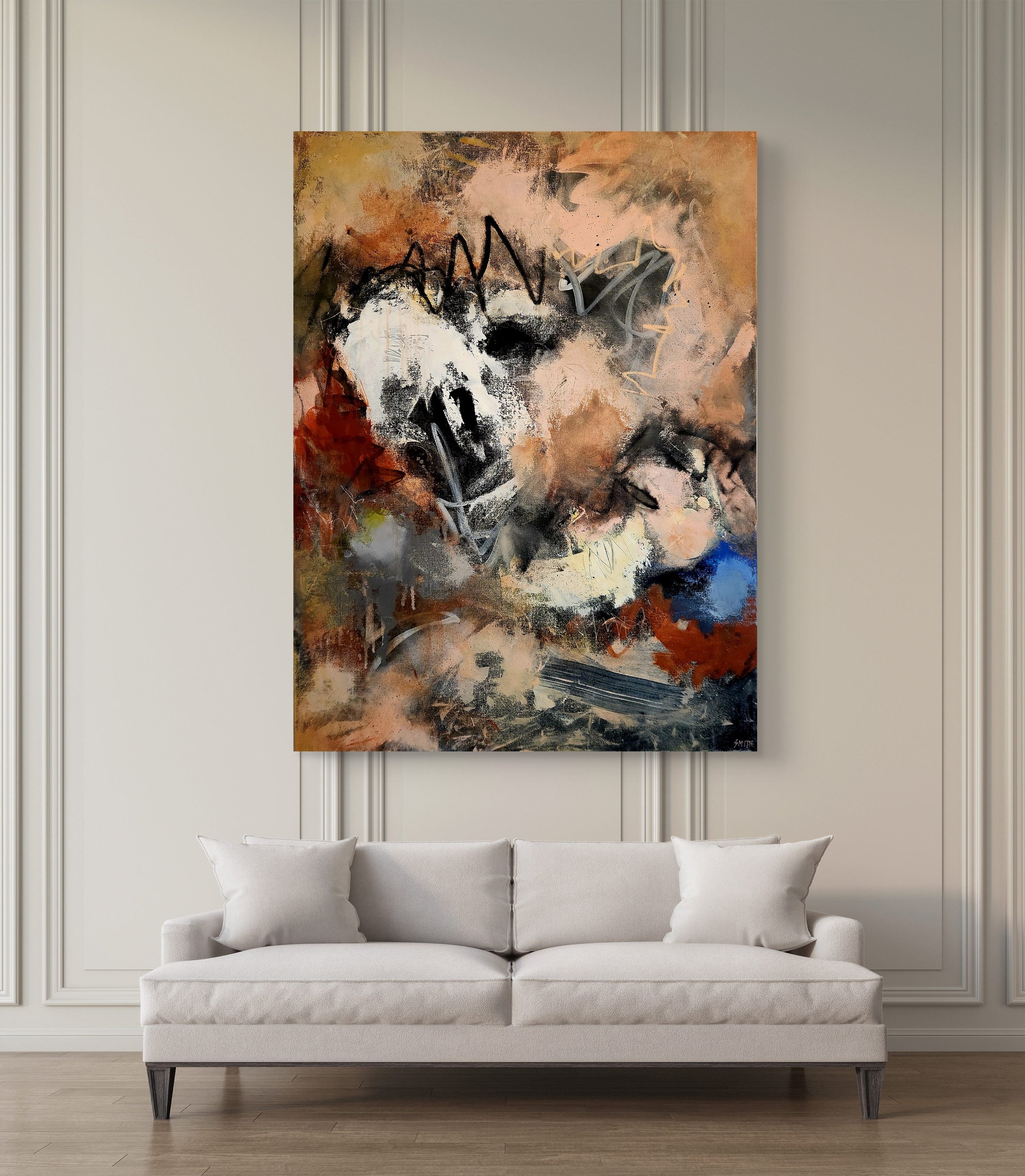 Abstract painting of a dog with black, white, brown, and blue colors hanging on a wall above a white couch in a room with white decorative wall panels.