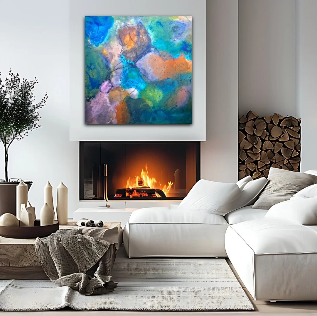 Modern living room with a fireplace, abstract colorful painting above it, white sofa, black and white throw blanket, decorative vases, a potted plant, and wood logs stacked beside the wall.