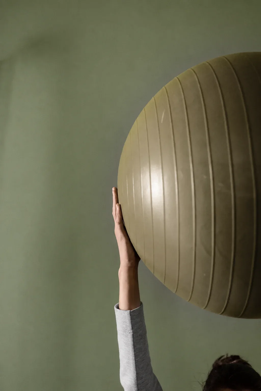 Mano apoyada sobre un fitball en el estudio de CALIX