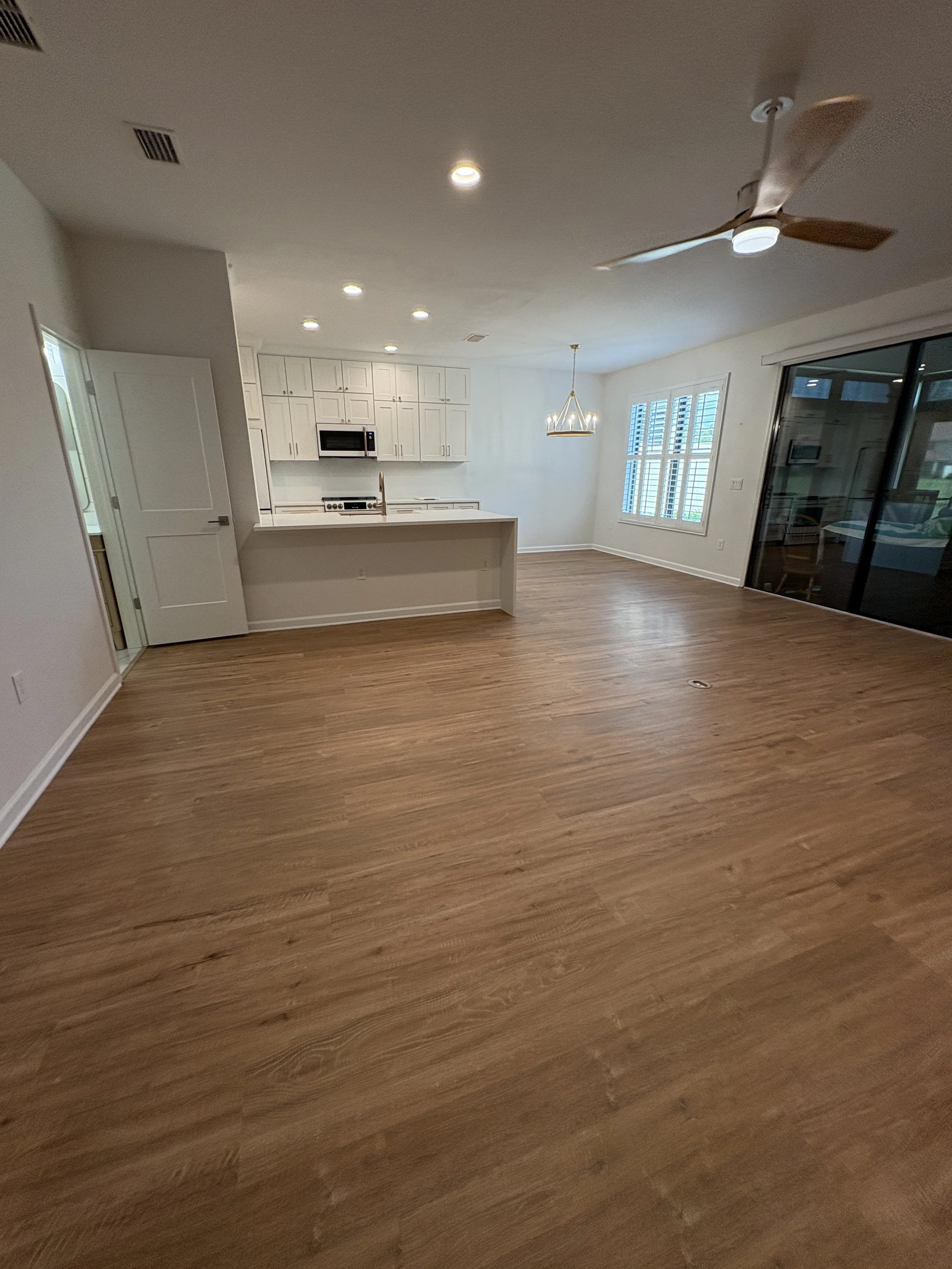 New wood-look flooring flows throughout the bright, open living area, creating a warm and cohesive finish in this high-end Jacksonville condo remodel by Elite Construction of JAX.