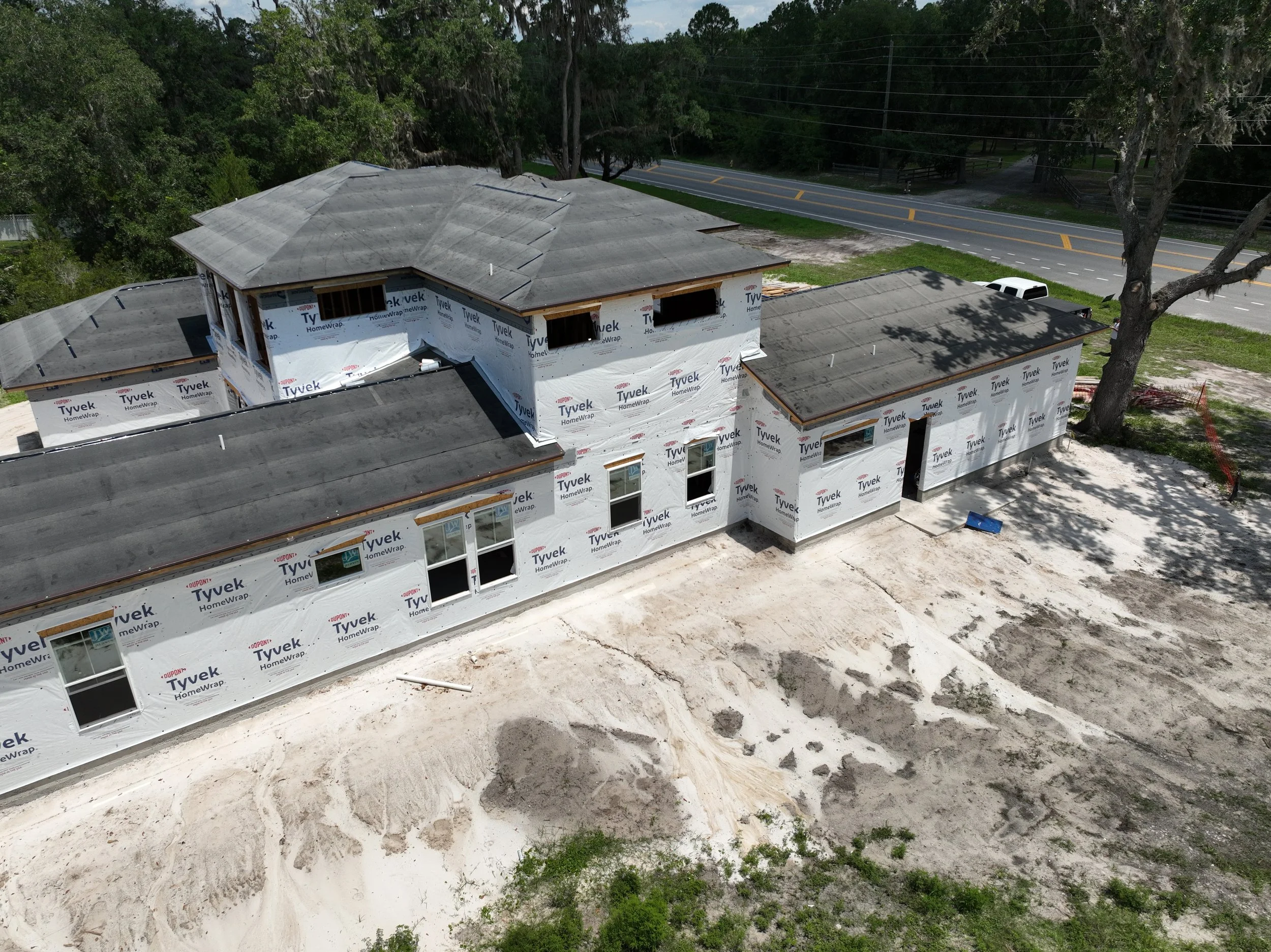 This aerial view captures the rear design and expansive roofline of a luxury custom home under construction off State Road 16 near SilverLeaf in St. Augustine, Florida. Elite Construction of JAX builds custom homes throughout St. Augustine, Jacksonvi