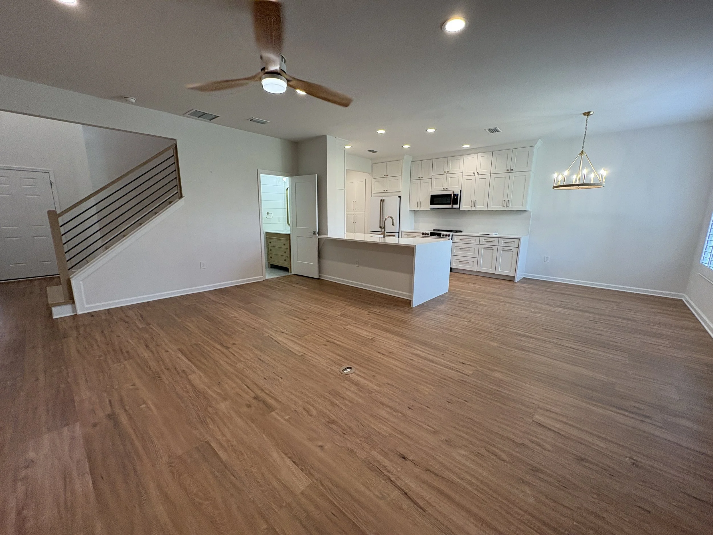 New wood-look flooring flows throughout the bright, open living area, creating a warm and cohesive finish in this high-end Jacksonville condo remodel by Elite Construction of JAX.