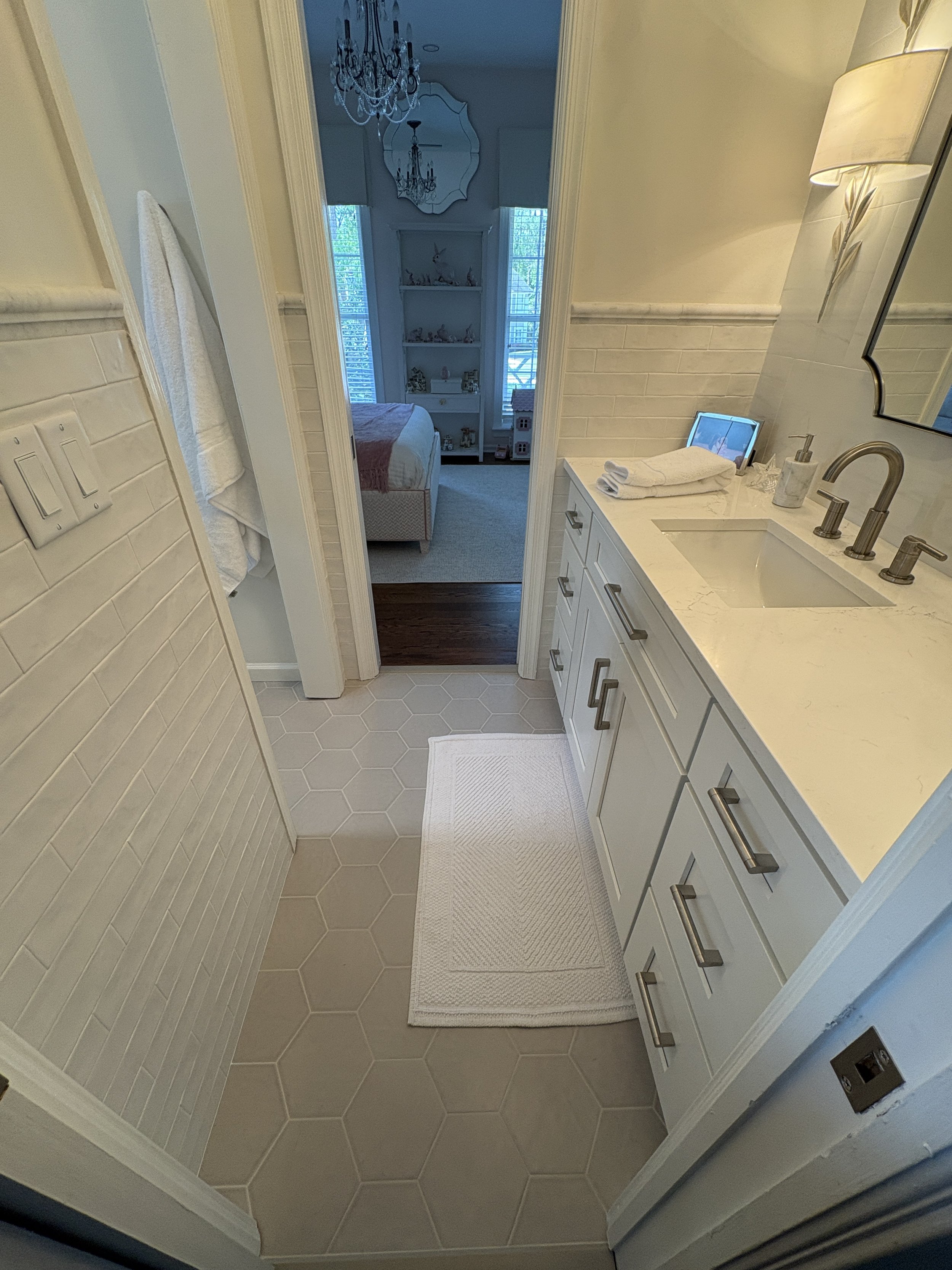 Finished bathroom vanity area featuring custom light-gray shaker cabinetry, quartz countertops, and brushed nickel fixtures that deliver a timeless blend of elegance and functionality. The streamlined layout maximizes storage and usability, while dec