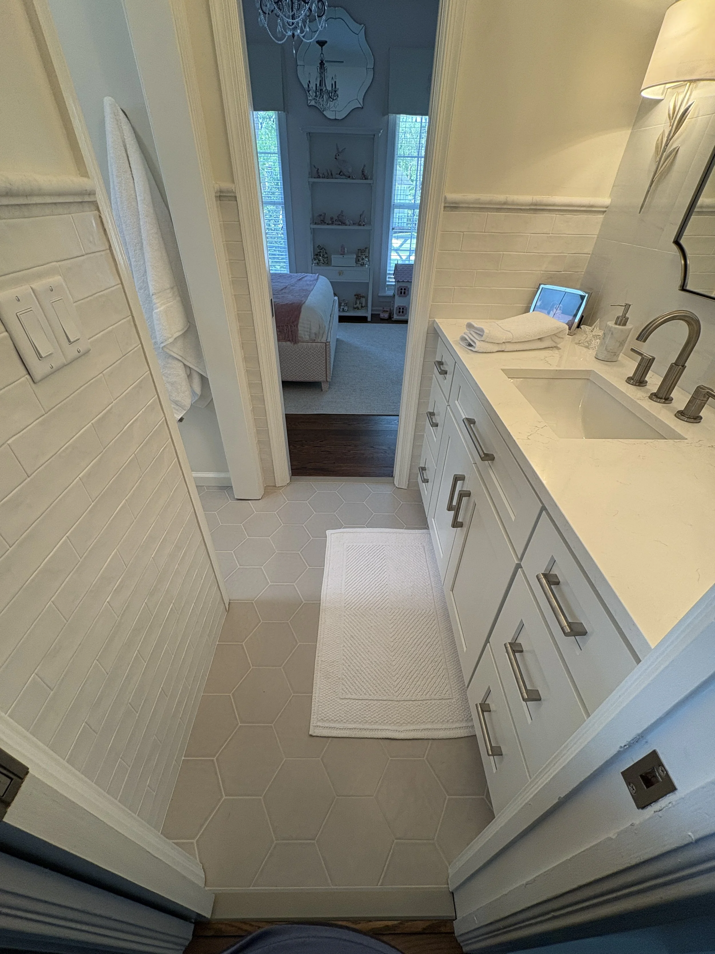 Finished bathroom vanity area featuring custom light-gray shaker cabinetry, quartz countertops, and brushed nickel fixtures that create a clean, timeless aesthetic. The thoughtfully designed layout maximizes functionality with ample storage, elegant 