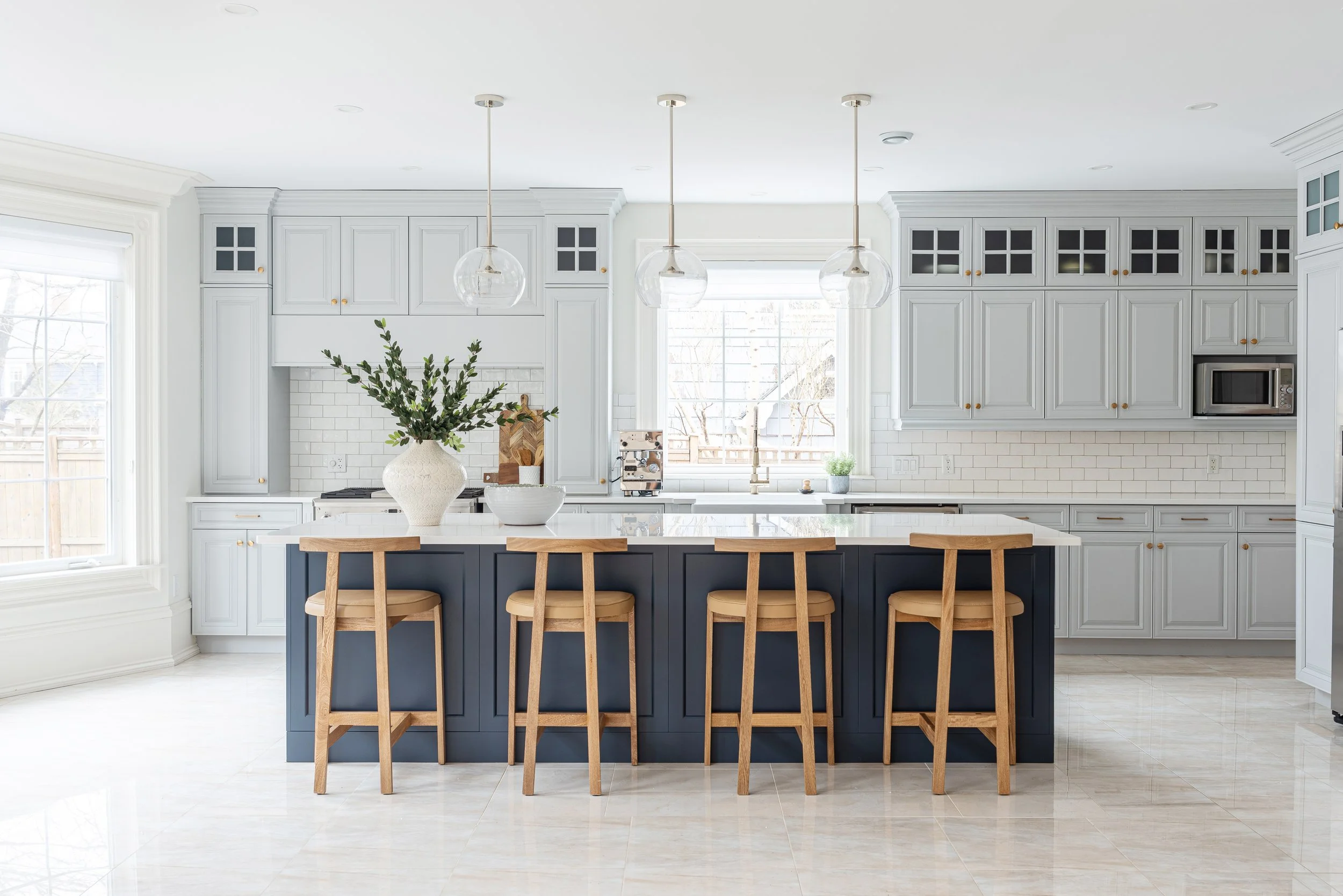 Bright, staged kitchen in Halifax home with pendant lighting, white cabinetry, dark island, and natural light — professional home staging Halifax NS