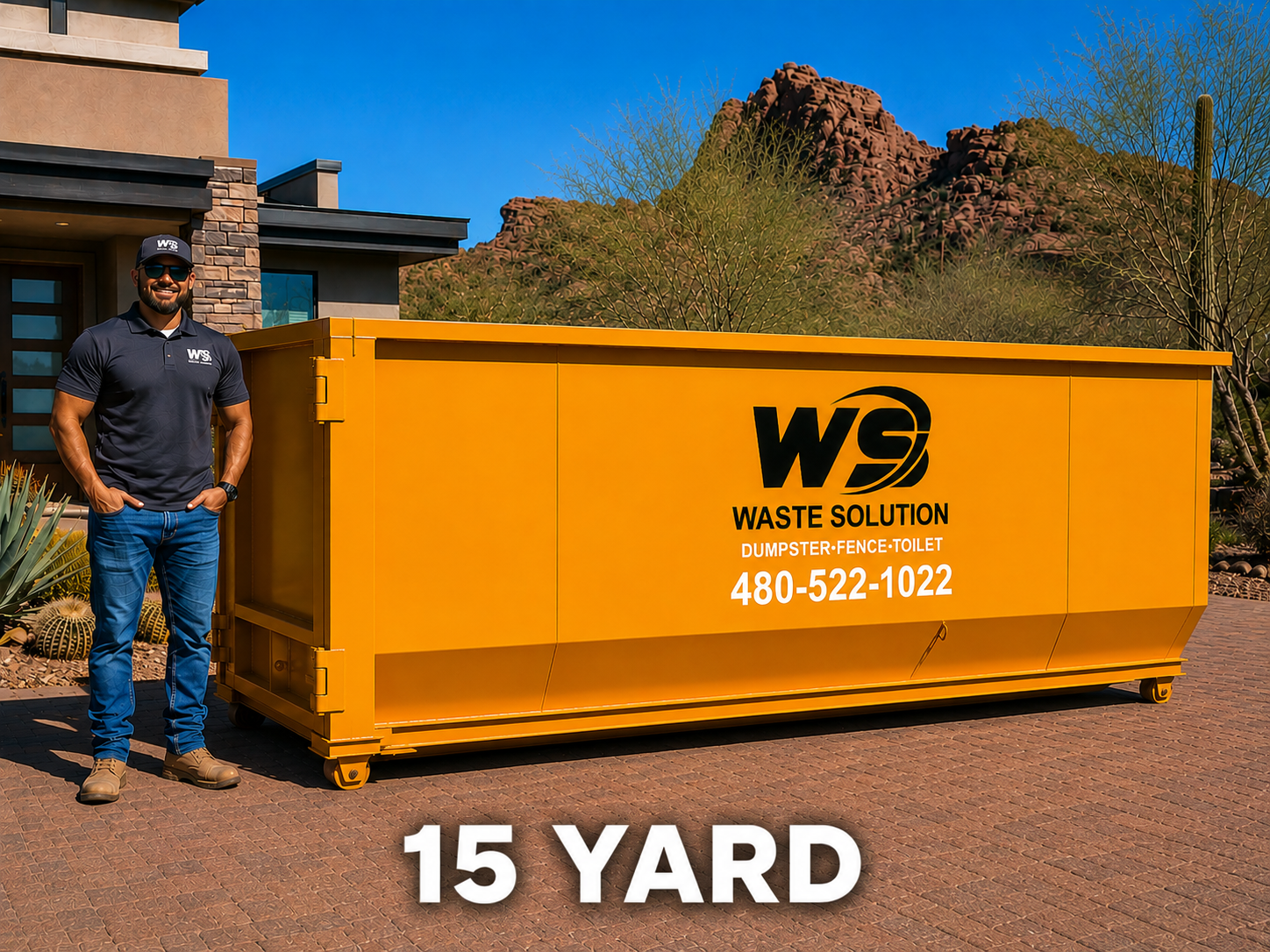 A man in a black polo shirt, blue jeans, and tan boots stands next to a large yellow Waste Solution dumpster with a mountain and desert plants in the background.