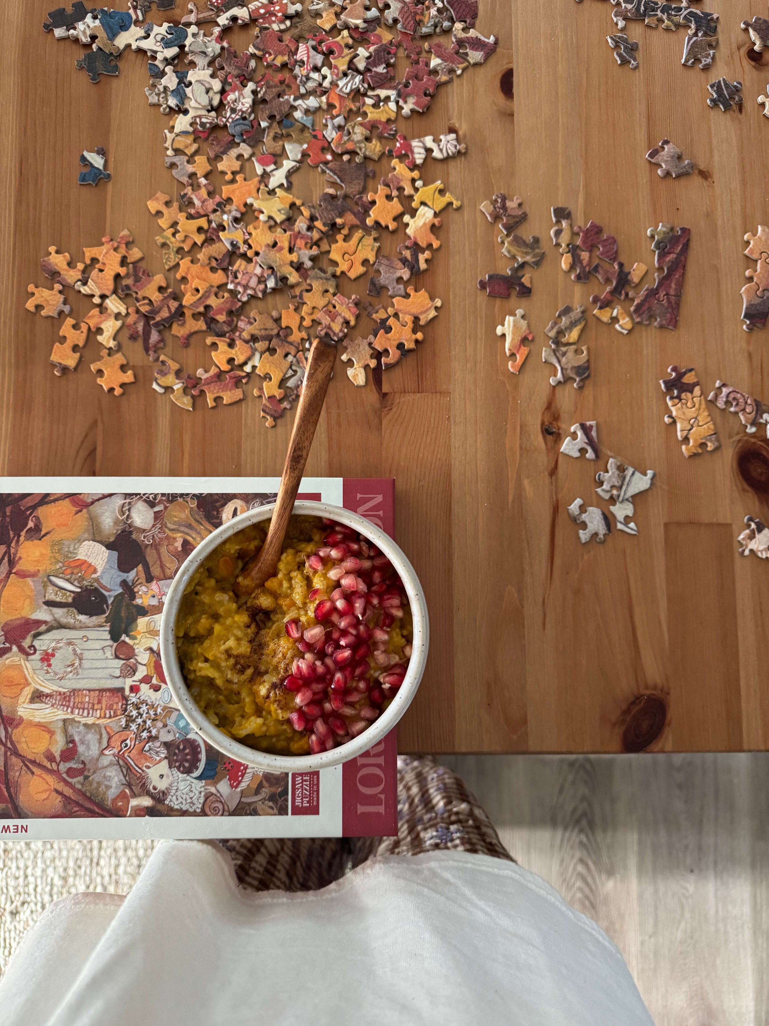 congee in bowl in kitchen with pomegranate seeds pumpkin flowers autumn kitchen counter puzzle