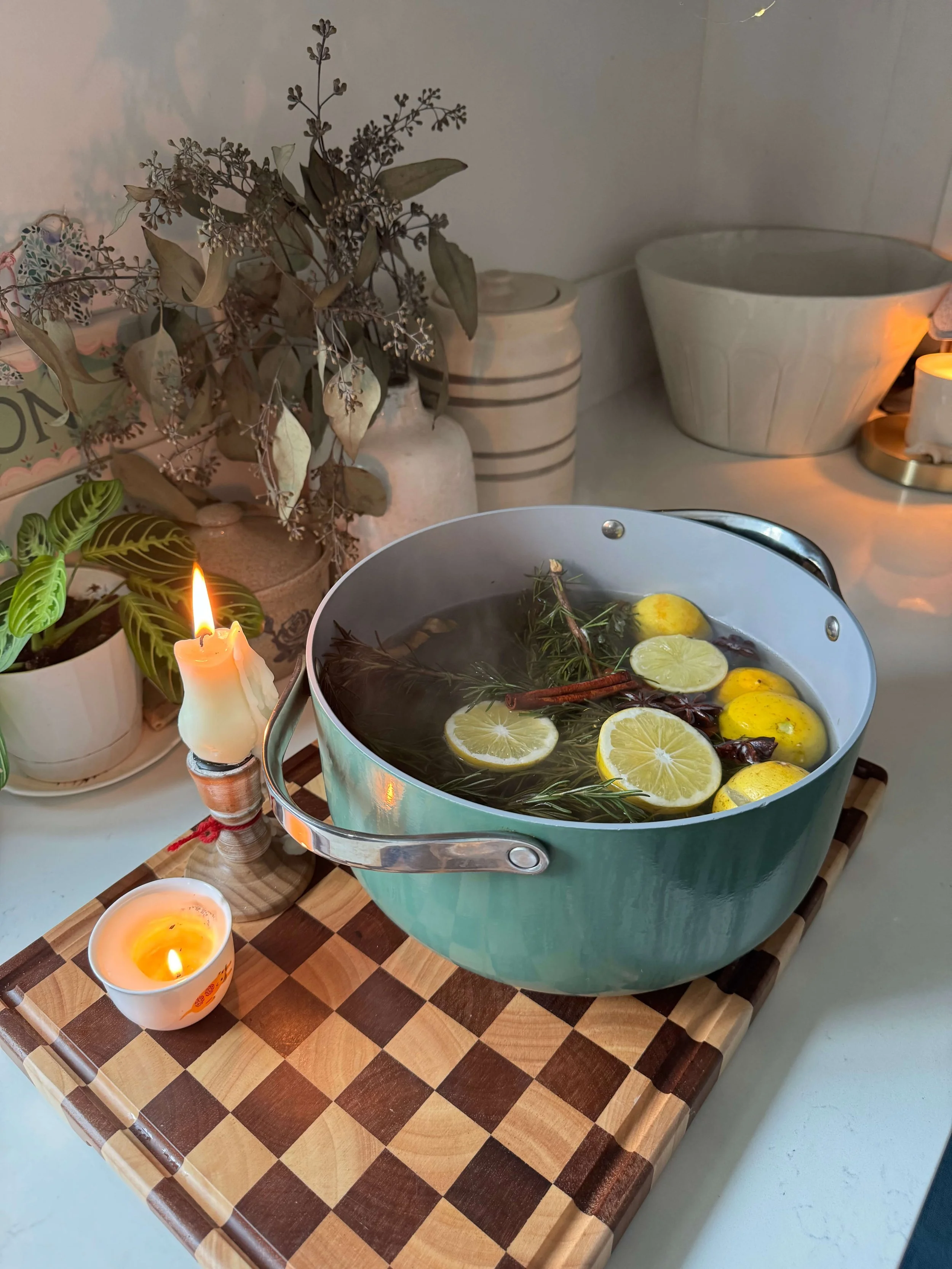 simmer pot on the counter in kitchen with steam lemon slices rosemary sprigs candles