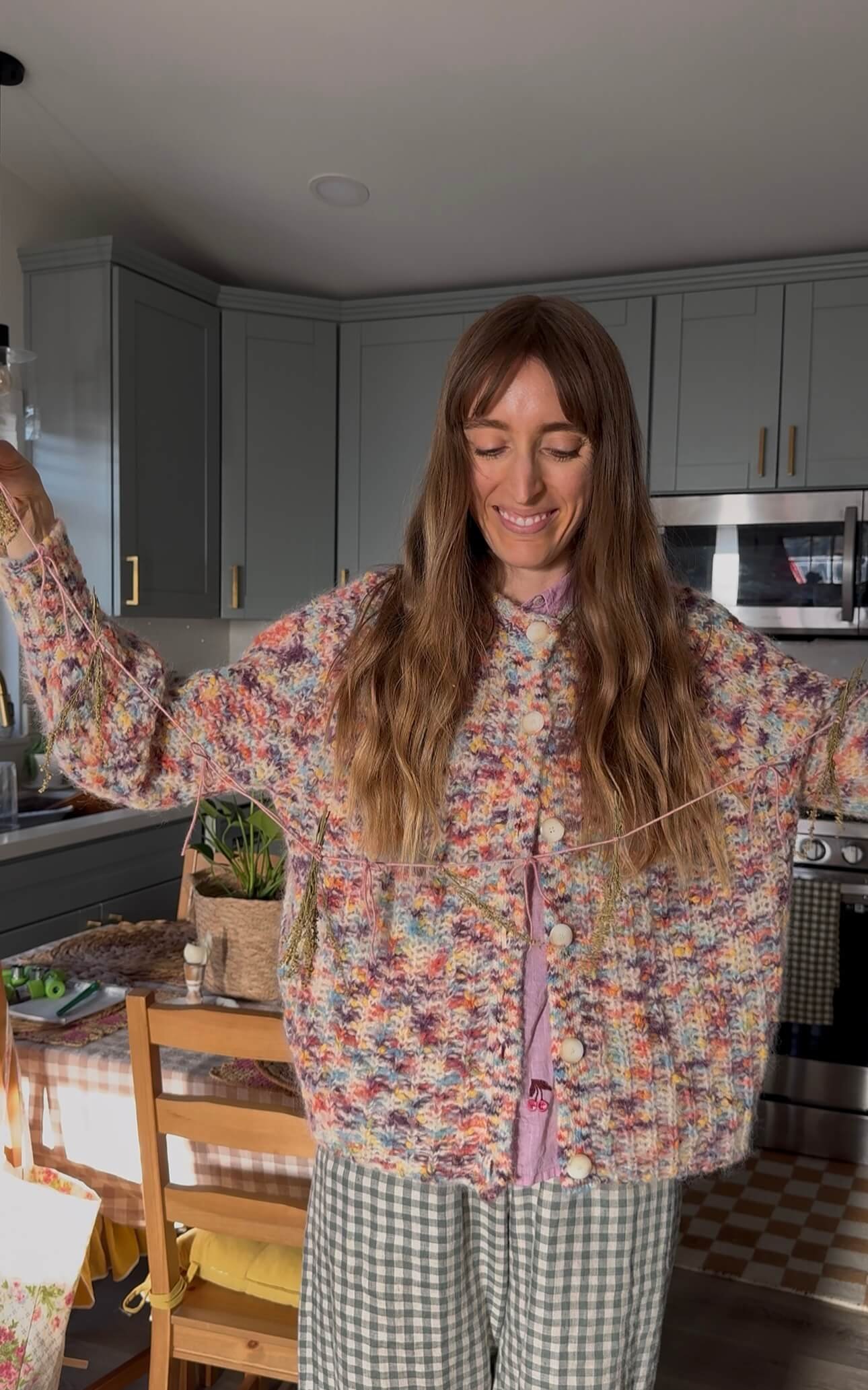 postpartum doula holding pink garland in kitchen