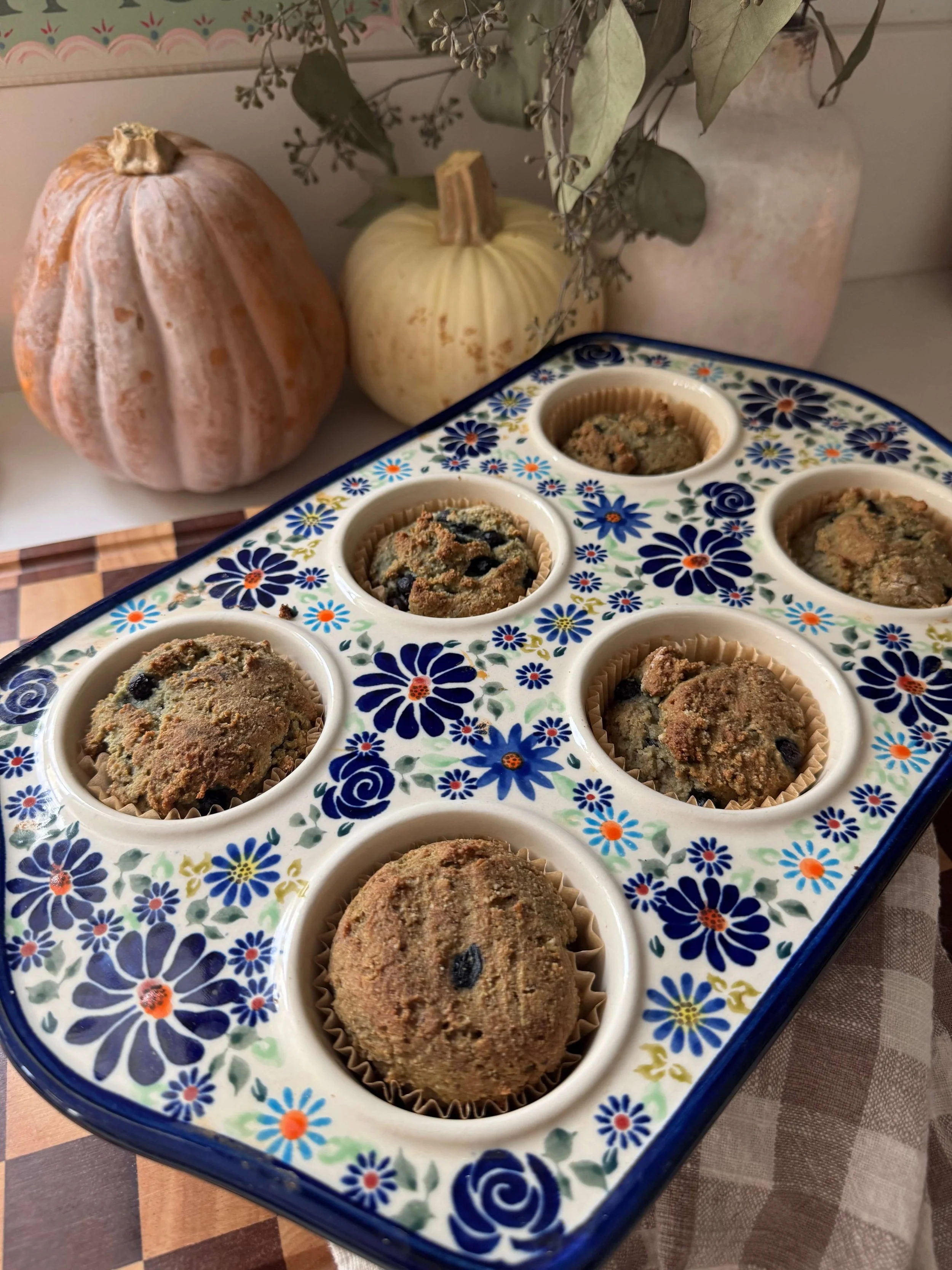 blueberry muffins in pan blue floral muffin pan on counter with pumpkins