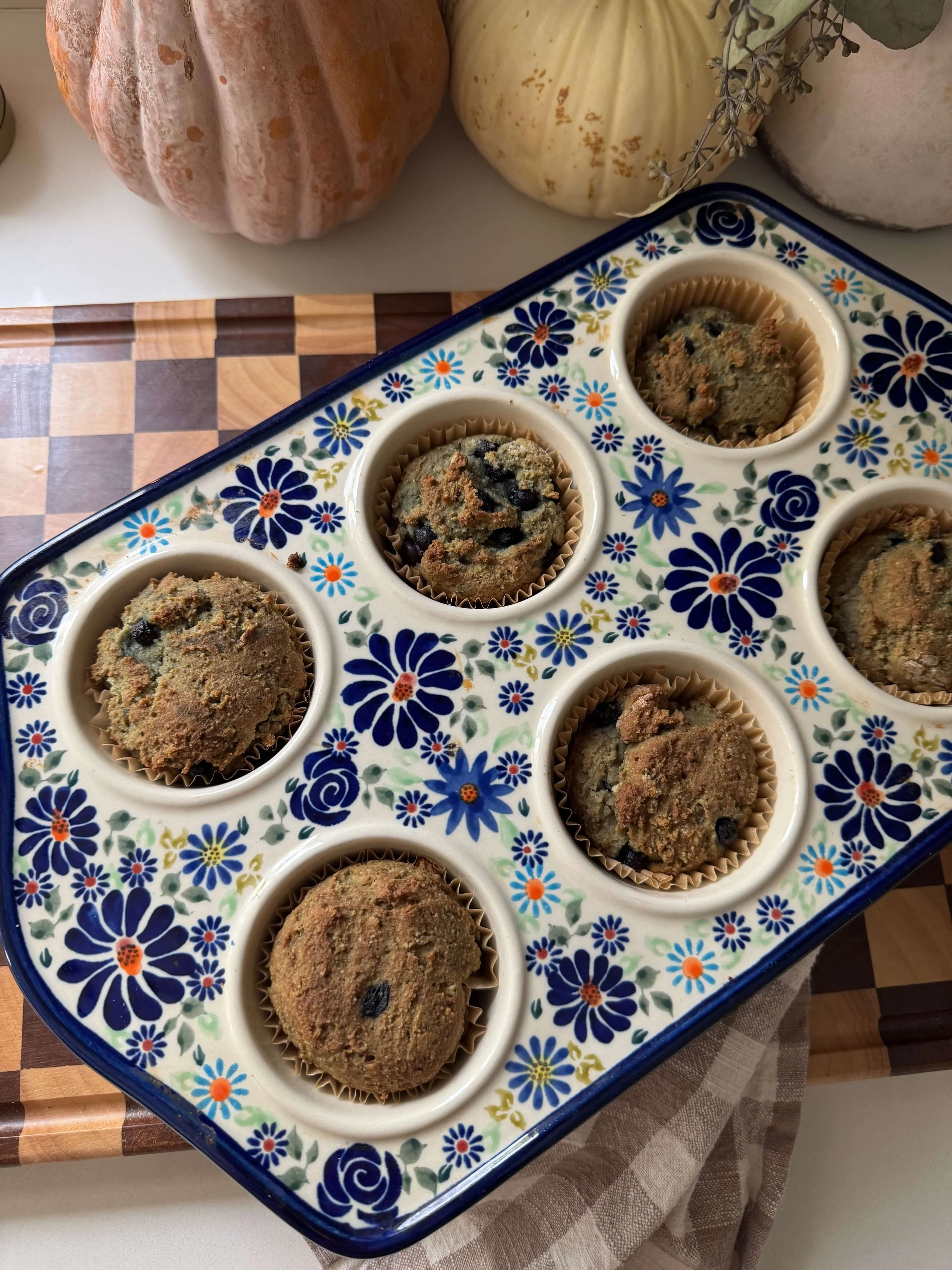 blueberry muffins in pan blue floral muffin pan on counter with pumpkins