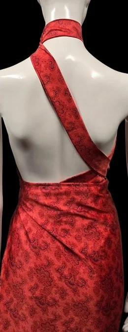 Red satin halter dress with embroidered floral resort-inspired detailing
