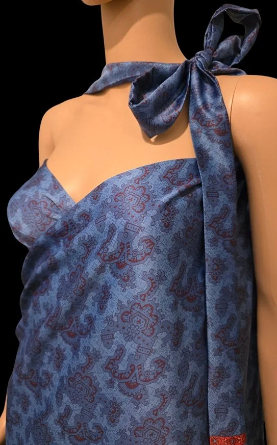 Elegant blue silk sarong styling with tropical floral scarf detail
