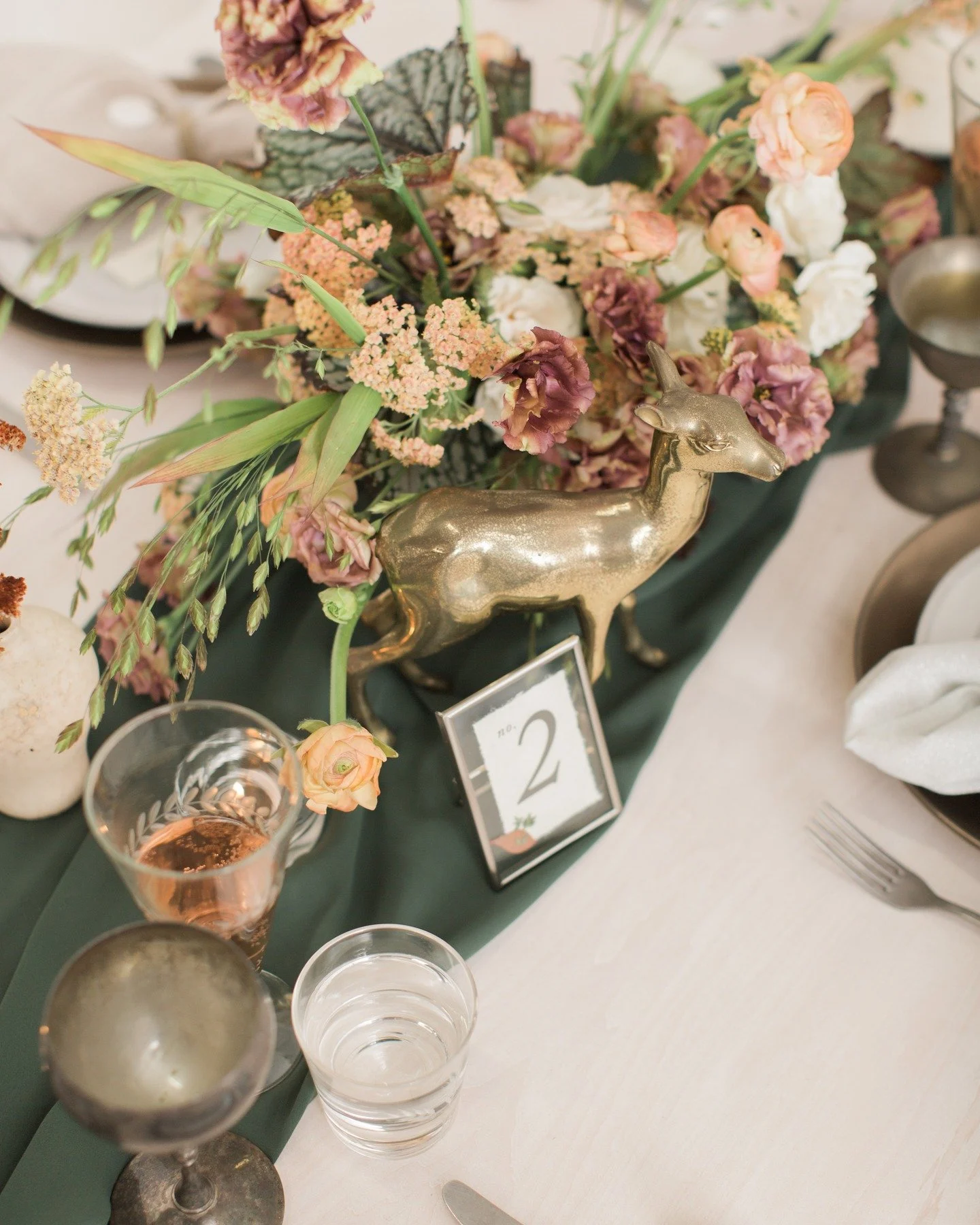 Fall weddings just feel extra special

This table design brought together rich green tones, textured florals, and antique metallic touches to create something warm, elegant, and a little bit unexpected

The deep green runner anchors the look while go