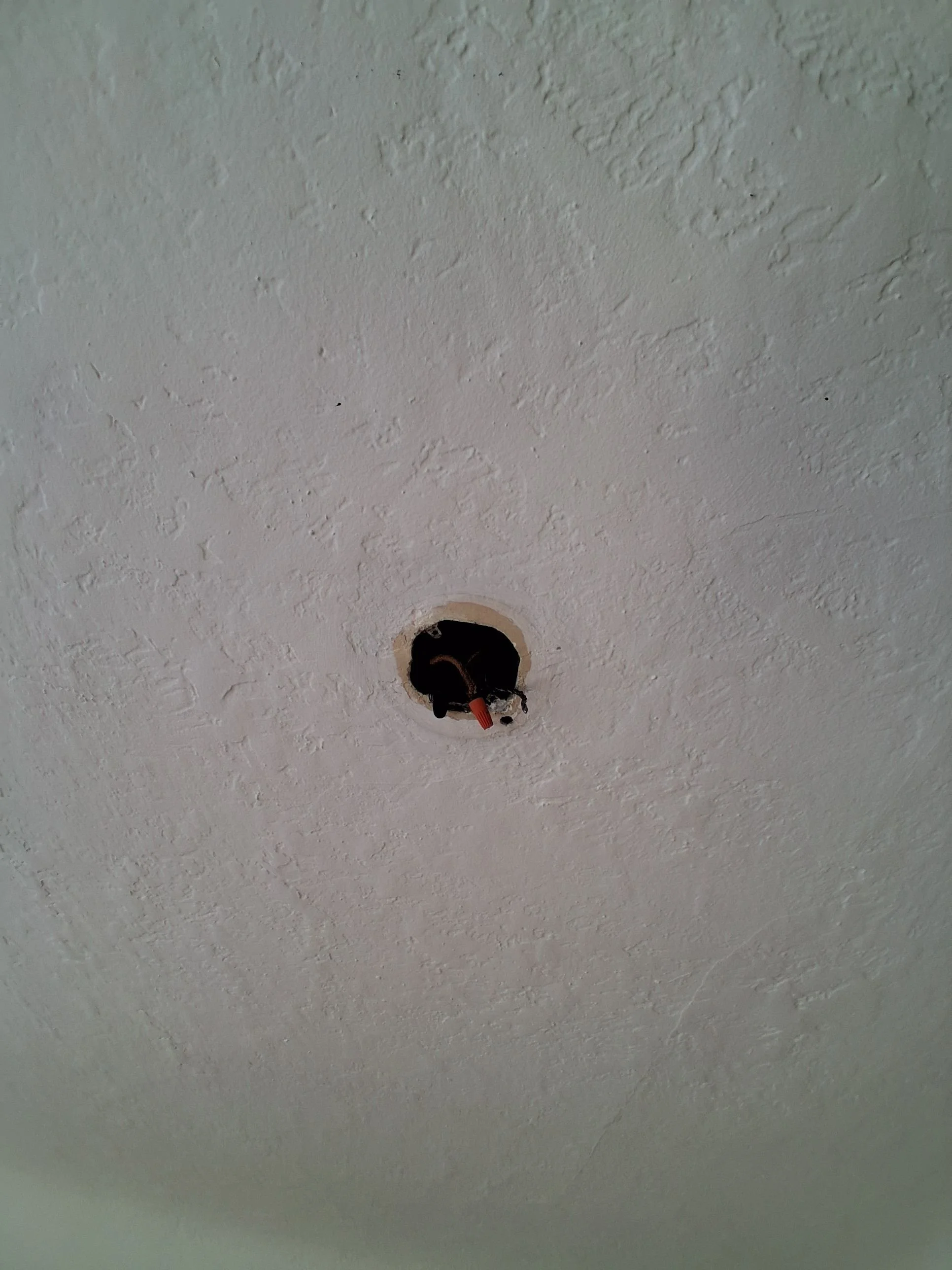 Existing wiring safely capped inside a textured plaster ceiling in an Oak Bay home before pot light installation