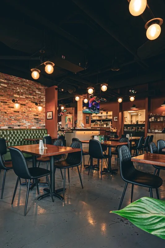 Pub dining room with pendant lighting and task lighting over the open kitchen pass