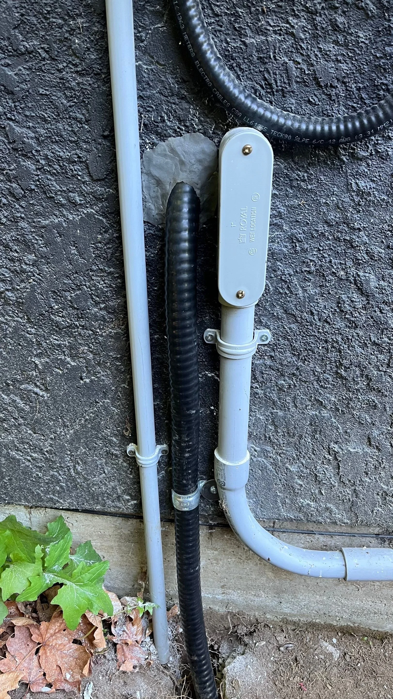 Teck90 cable and EMT conduit with a wet-location conduit body where the sauna feeder exits the house wall