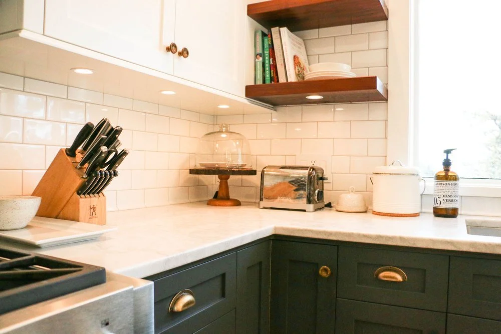 Under cabinet lighting and pot lights in a renovated kitchen with a subway tile backsplash