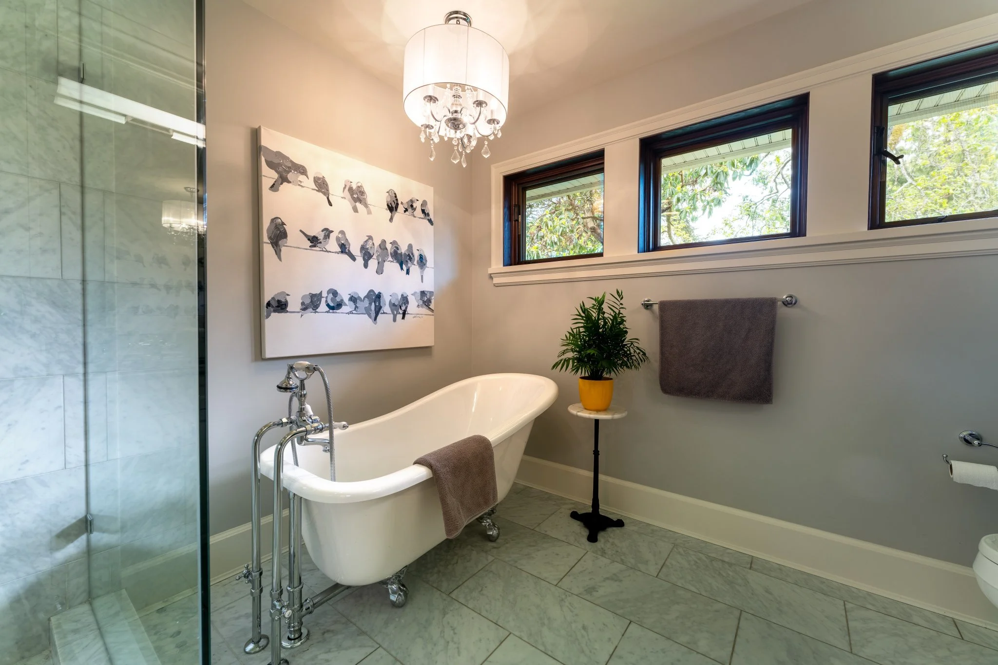 Crystal pendant fixture wired above a clawfoot tub in a finished Victoria bathroom reno
