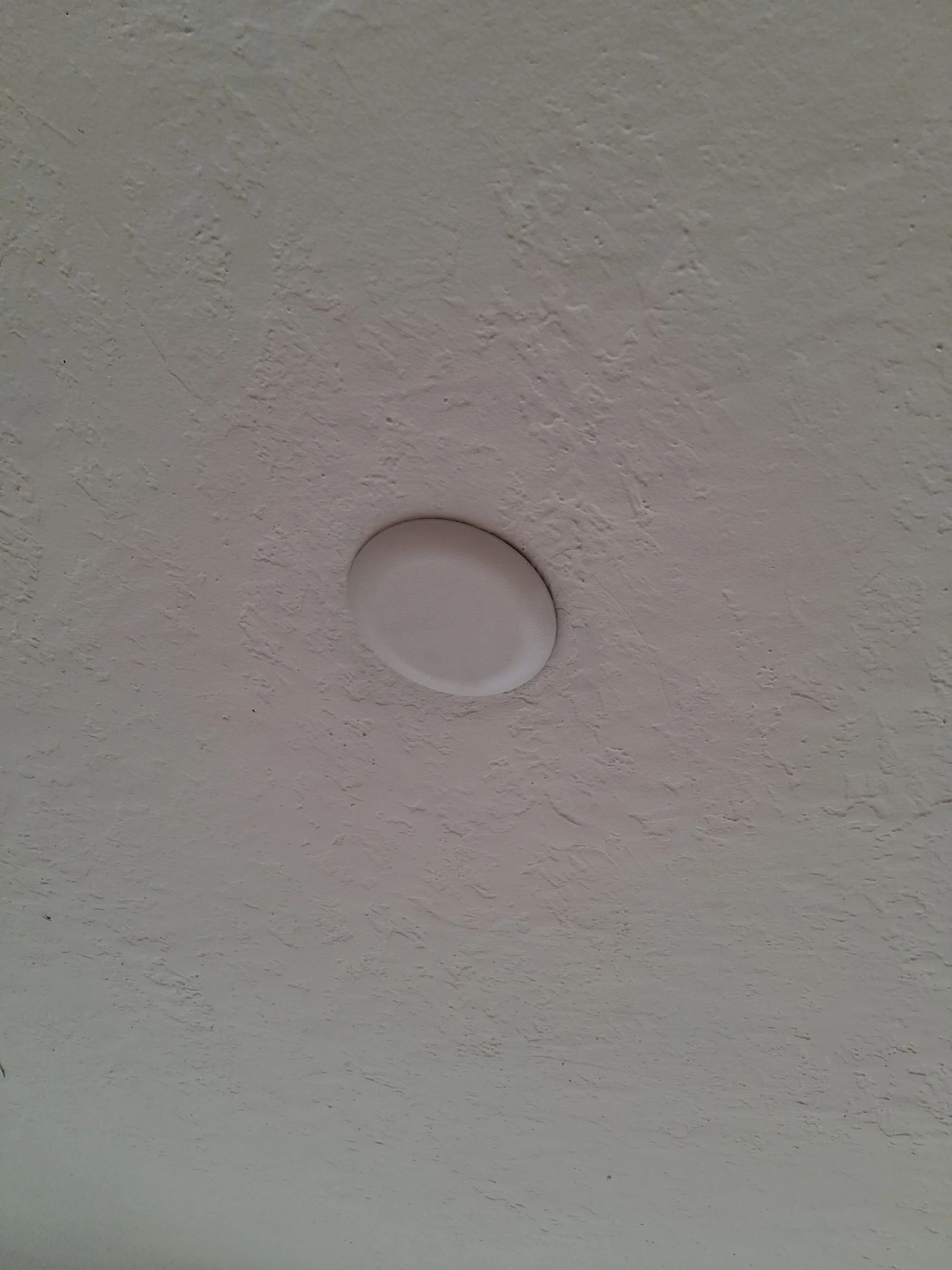Old fixture opening patched and blanked off in a lathe and plaster ceiling