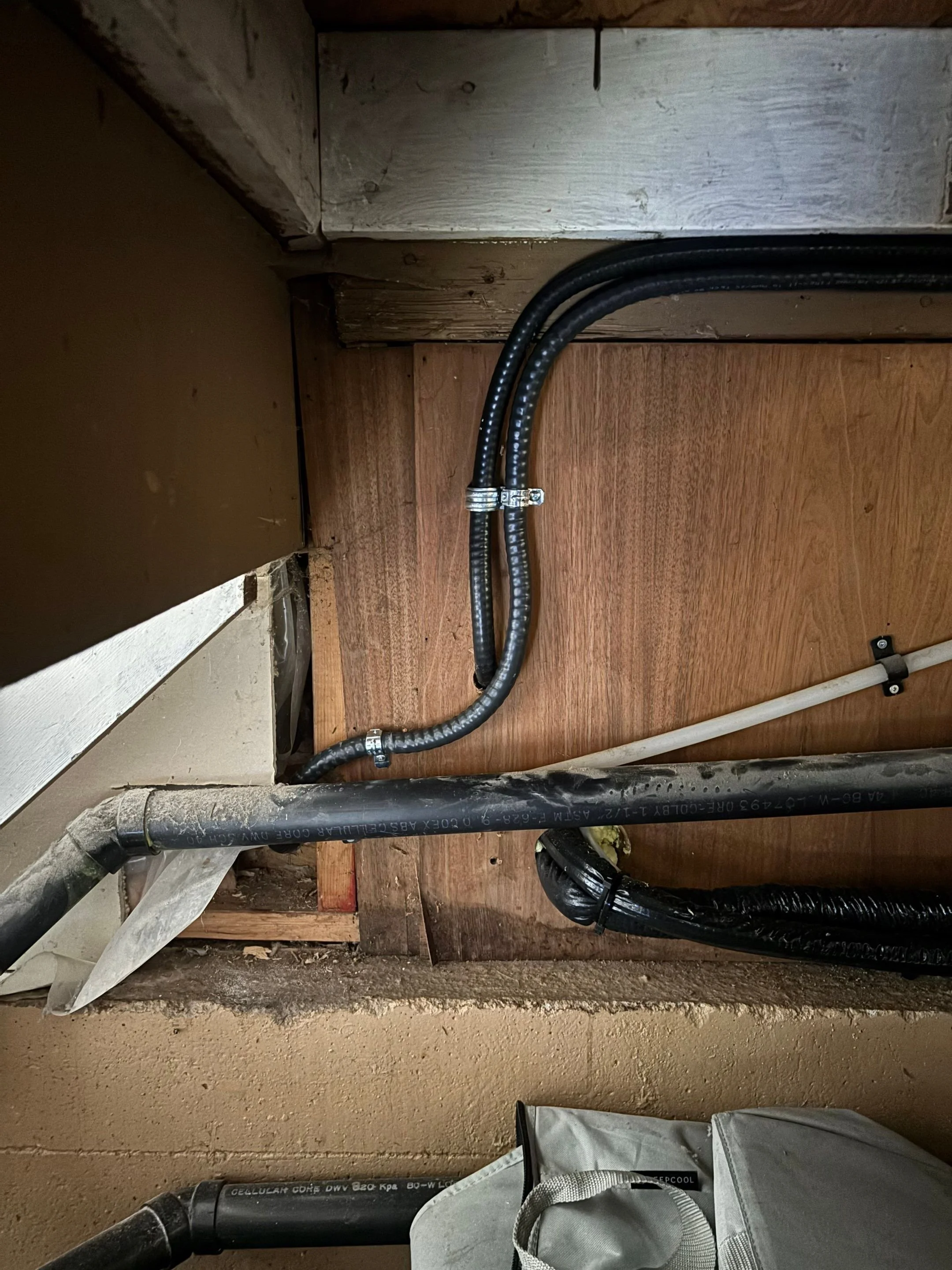 Heat pump circuit clipped and supported along joists across an unfinished basement