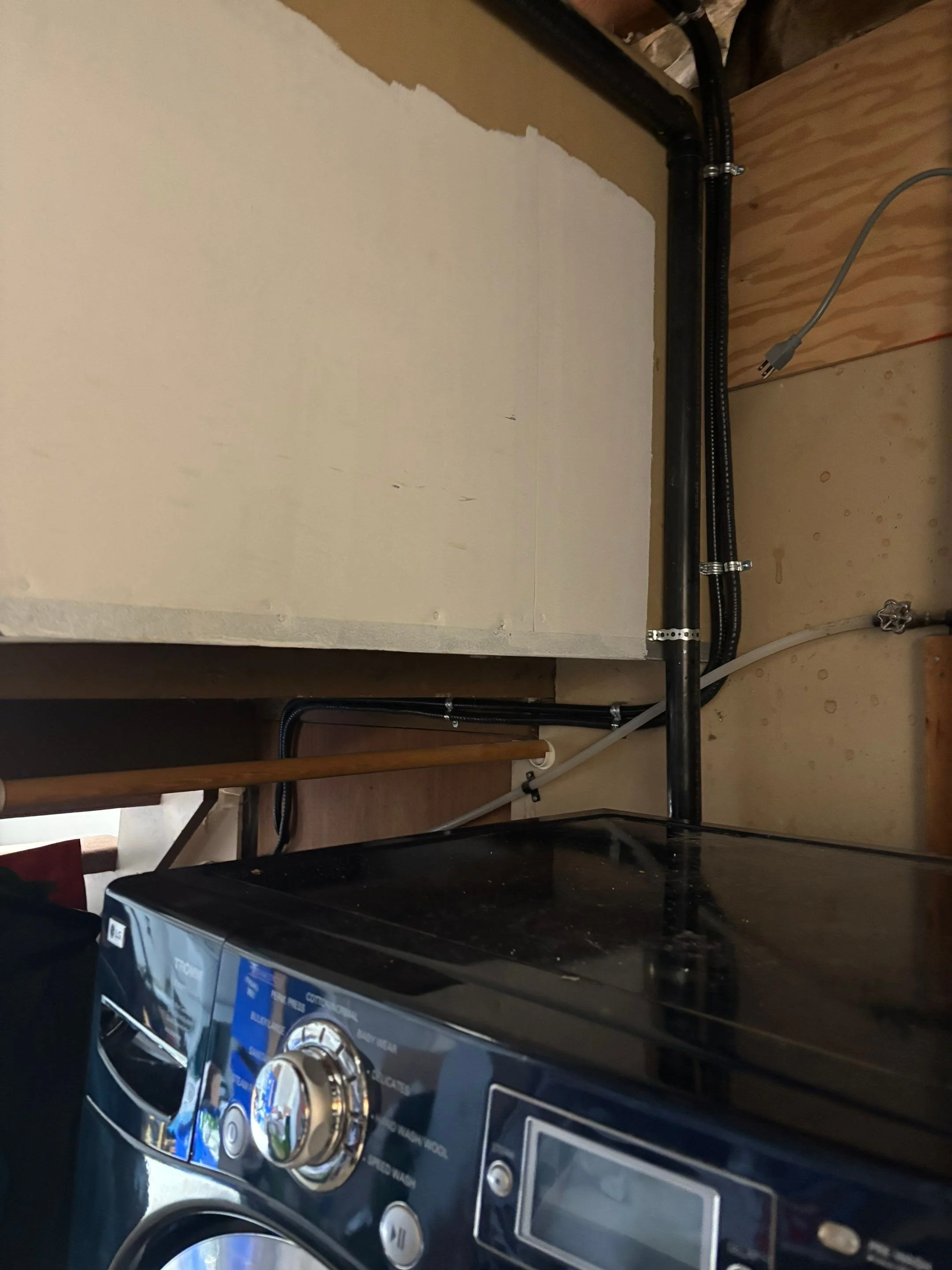 Dedicated heat pump circuit routed neatly past a washing machine in a basement