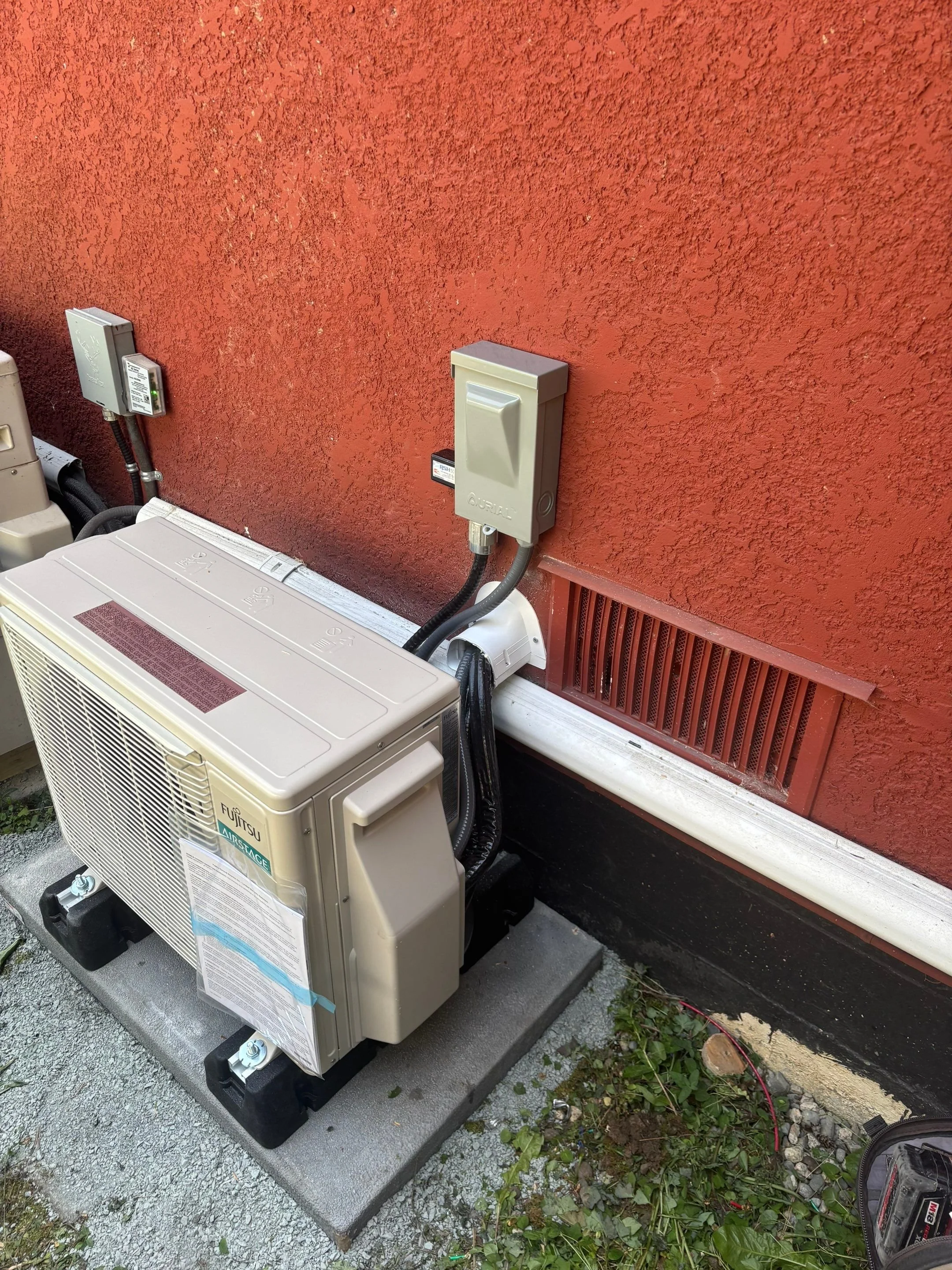 Outdoor electrical disconnect mounted beside a residential heat pump condenser